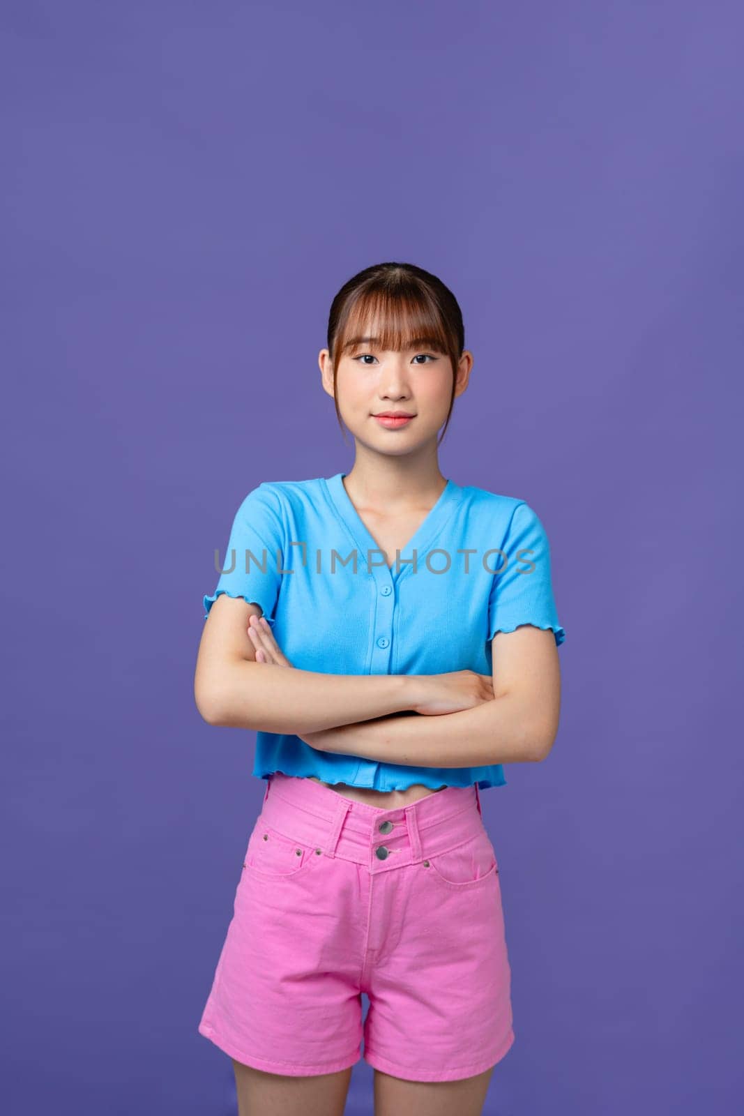 Image of a happy cheerful young pretty woman posing isolated over purple background looking aside.