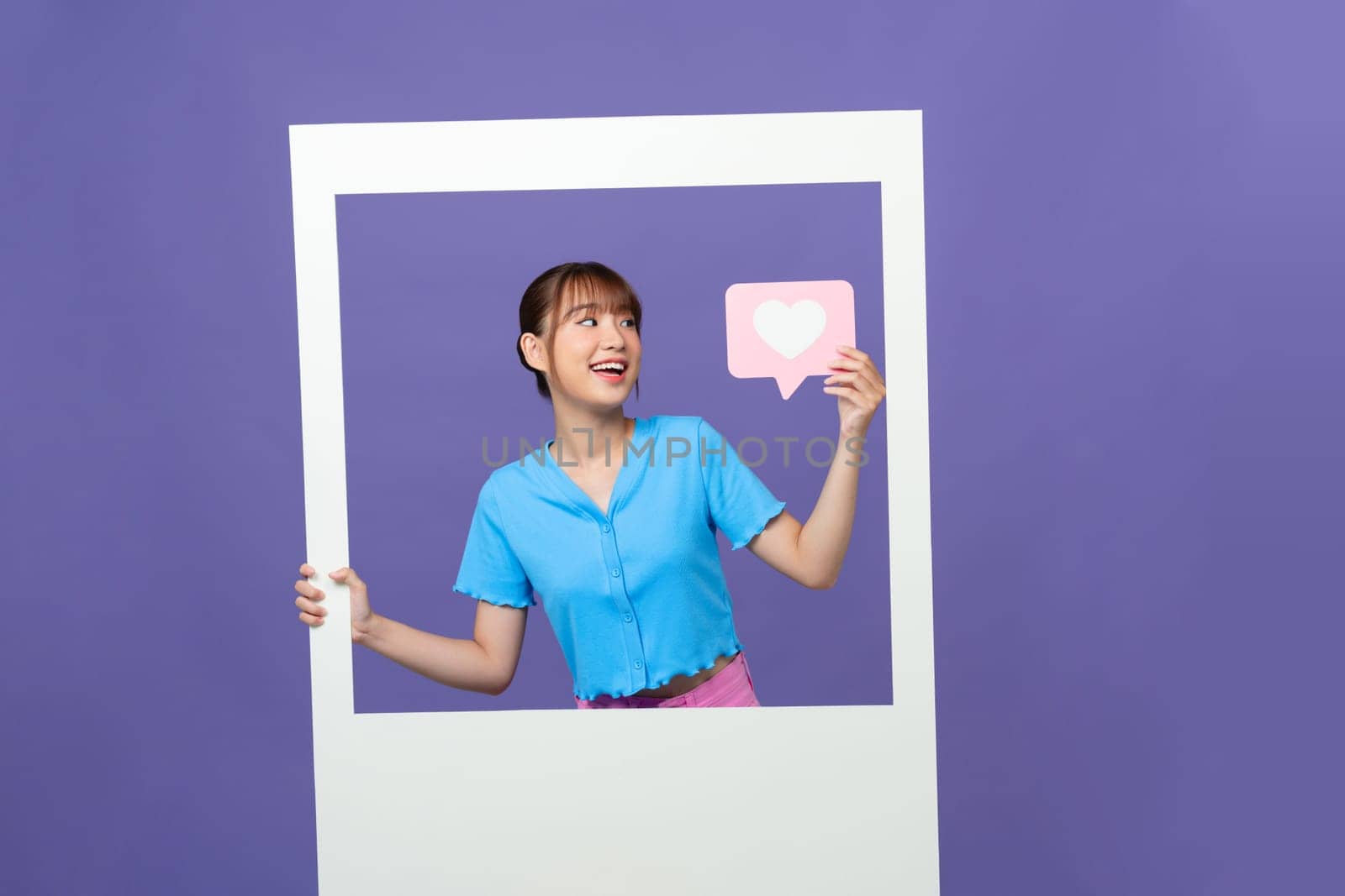 Positive astonished person hands hold Like icon in paper album card isolated on purple background by makidotvn