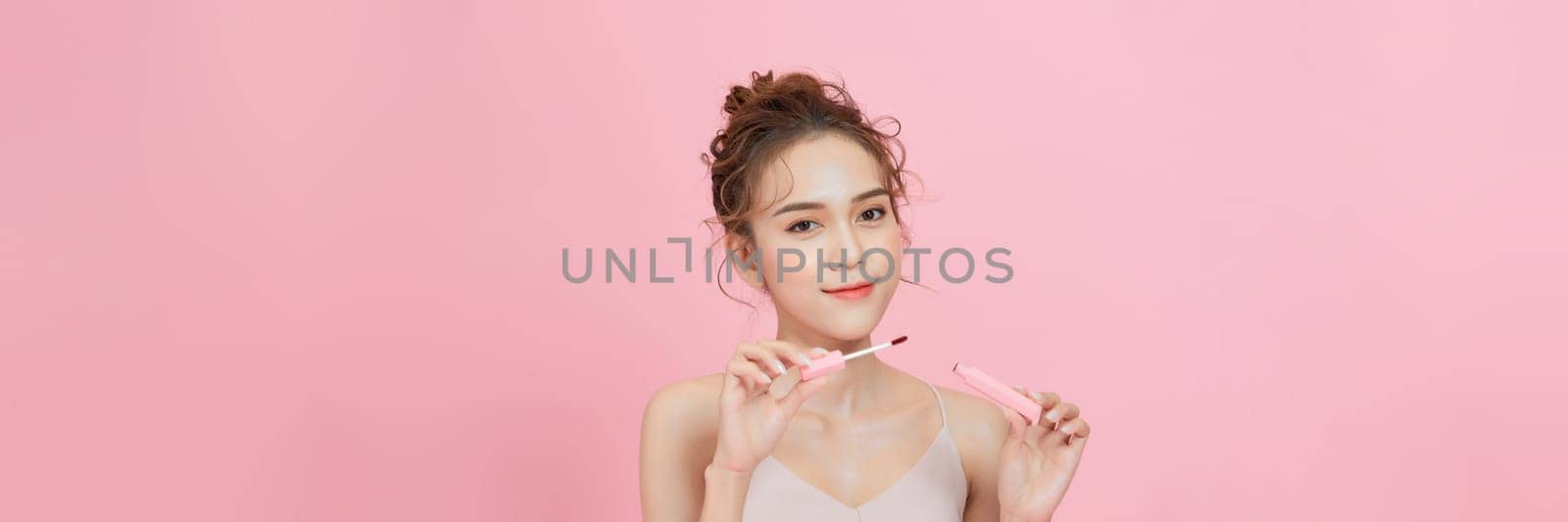 Photo of shirtless woman posing with lipstick, isolated studio background.