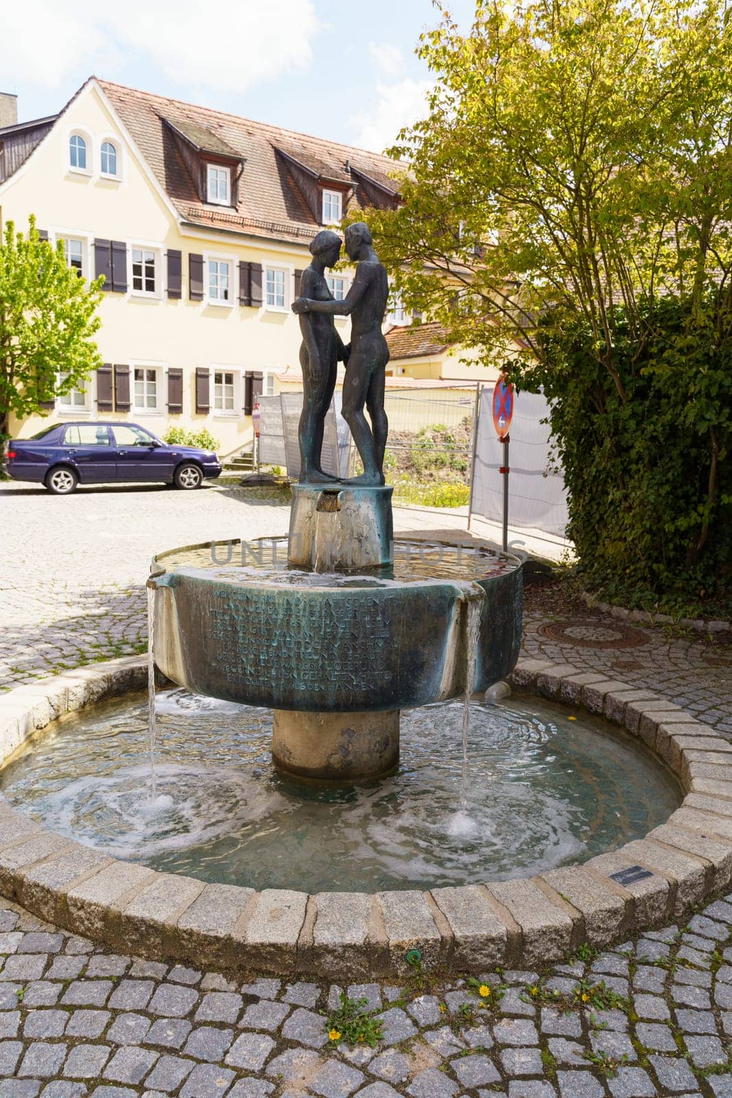 Feuchtwangen, Germany - May 6, 2023: Fountain, naked couple in love holding hands. Vertical frame