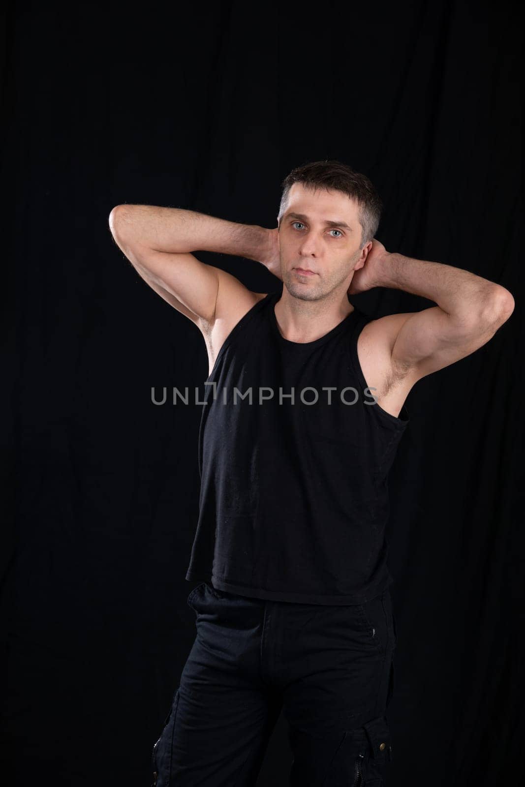 Man posing on a black background in a dark room by Simakov