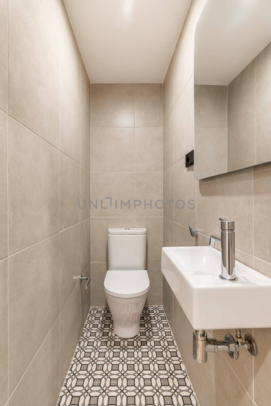 Narrow vanity area with toilet bowl washbasin and mirror by apavlin