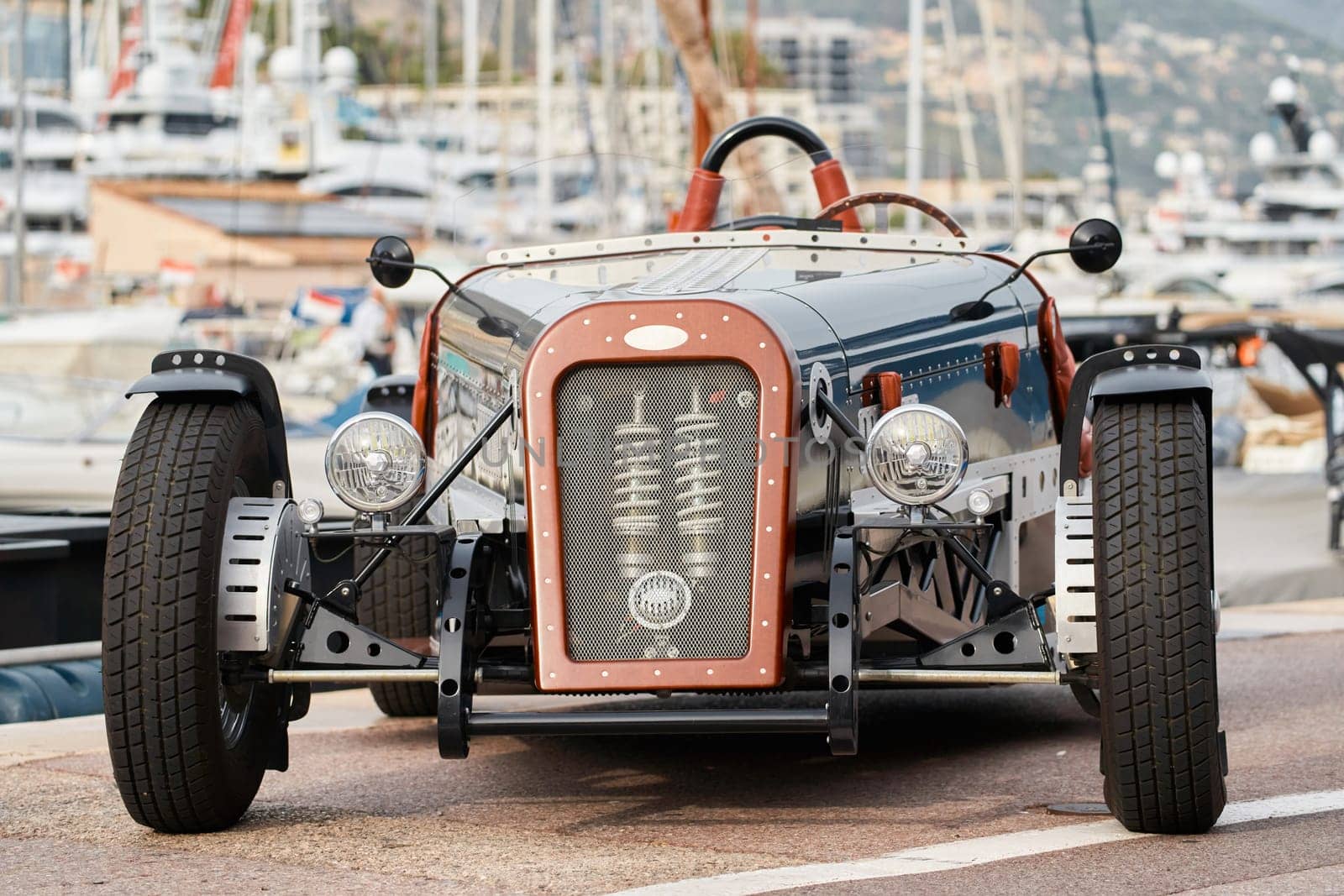 vintage open-top car at the yacht show in Monaco on a sunny day, leather seats, spoked wheels, close-up by vladimirdrozdin