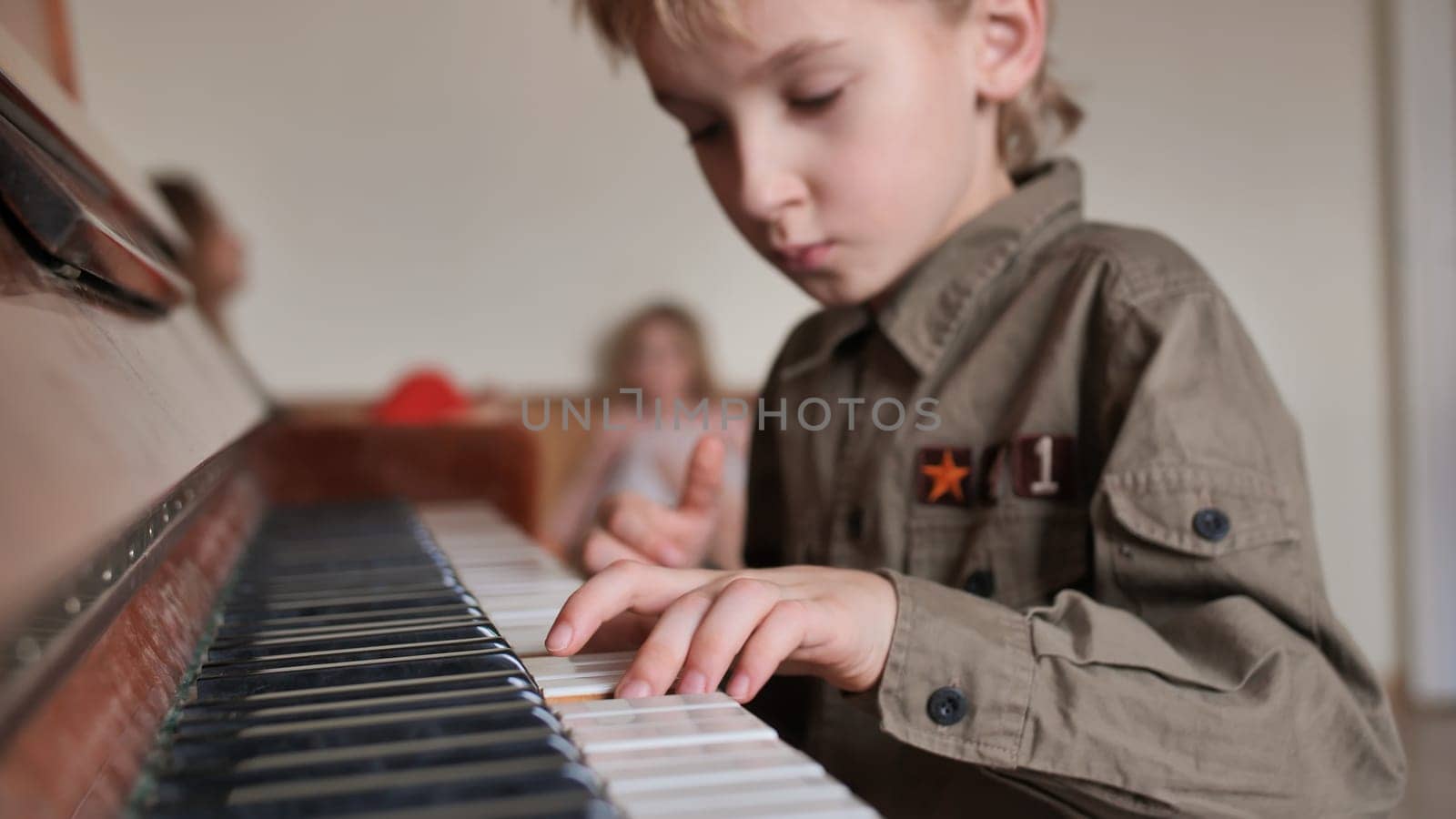 An eight-year-old boy plays the piano at home