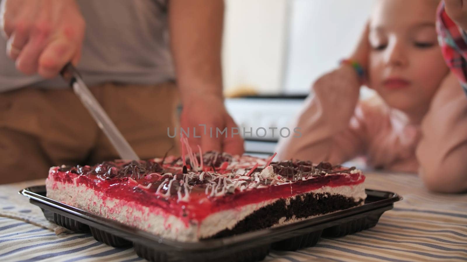 Father cuts the cake with the children. by DovidPro
