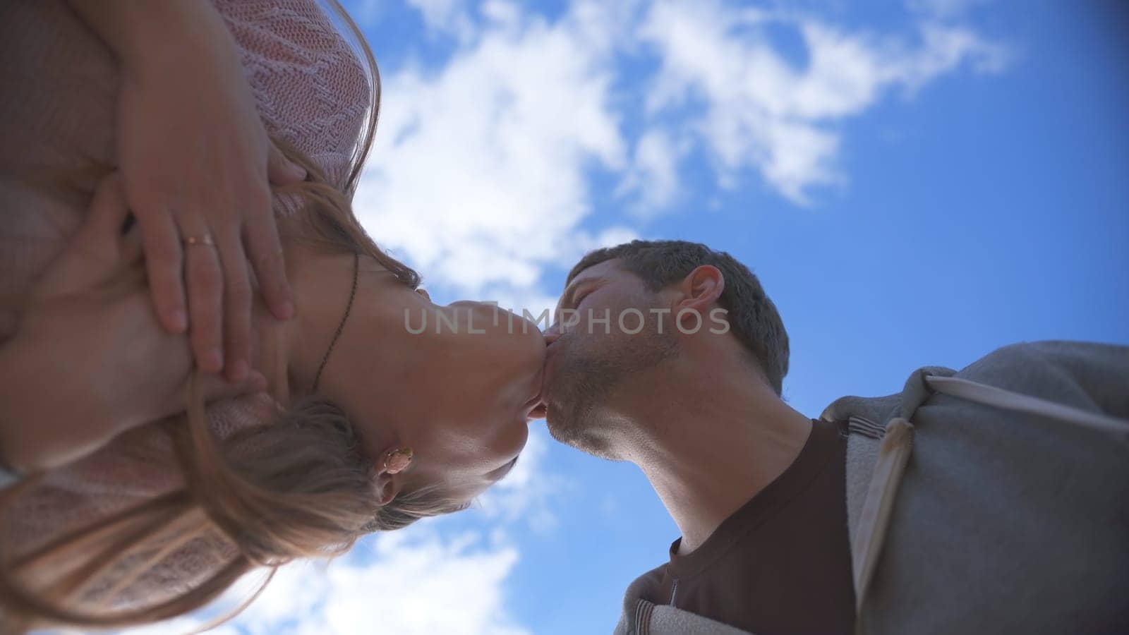 Amorous couple kissing on a background of blue sky