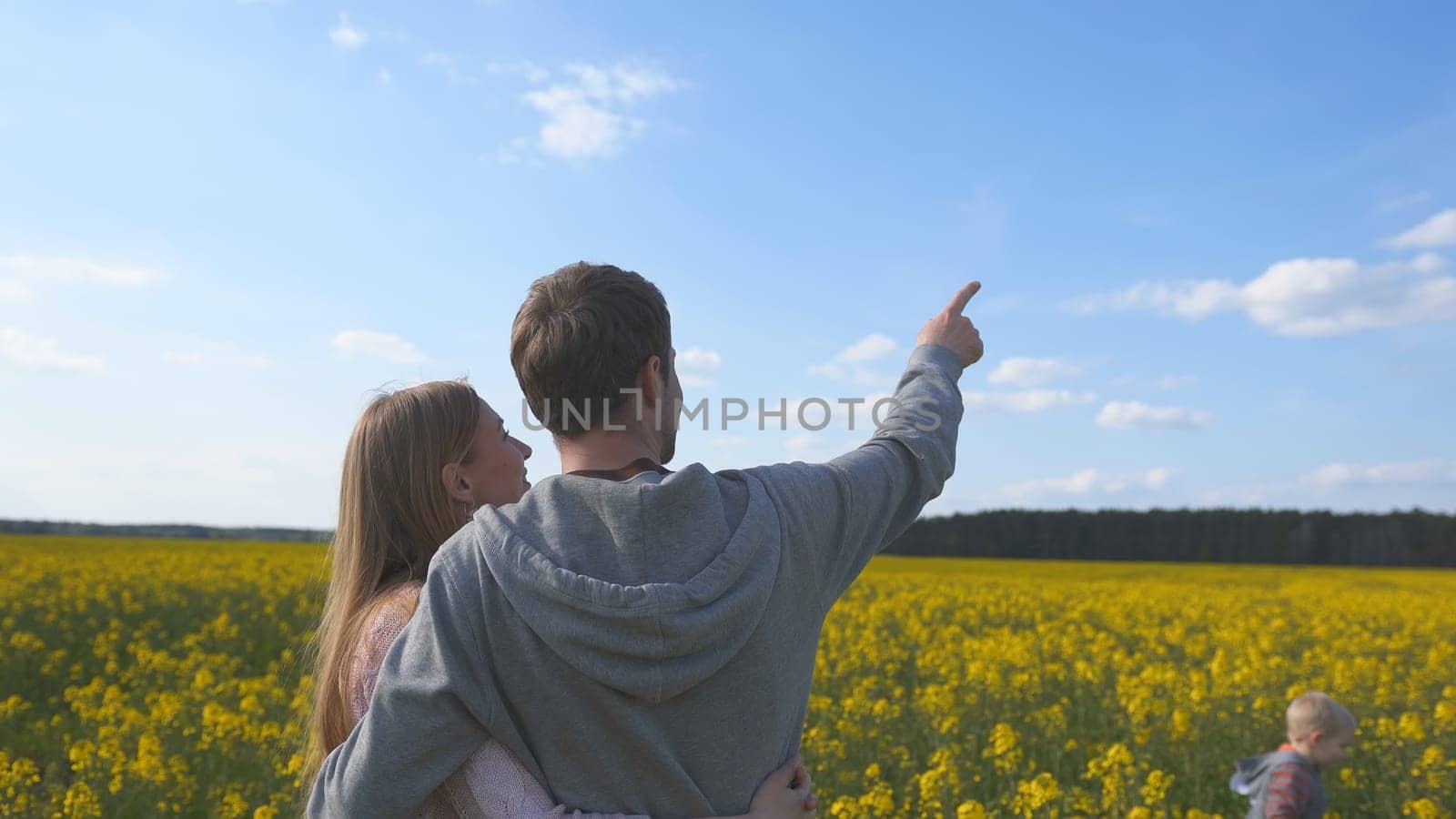 Happy family with kids in a rapeseed field. by DovidPro