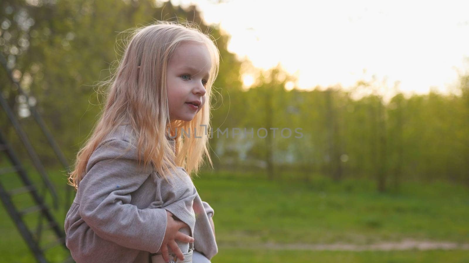 Little girl in the evening summer sunset
