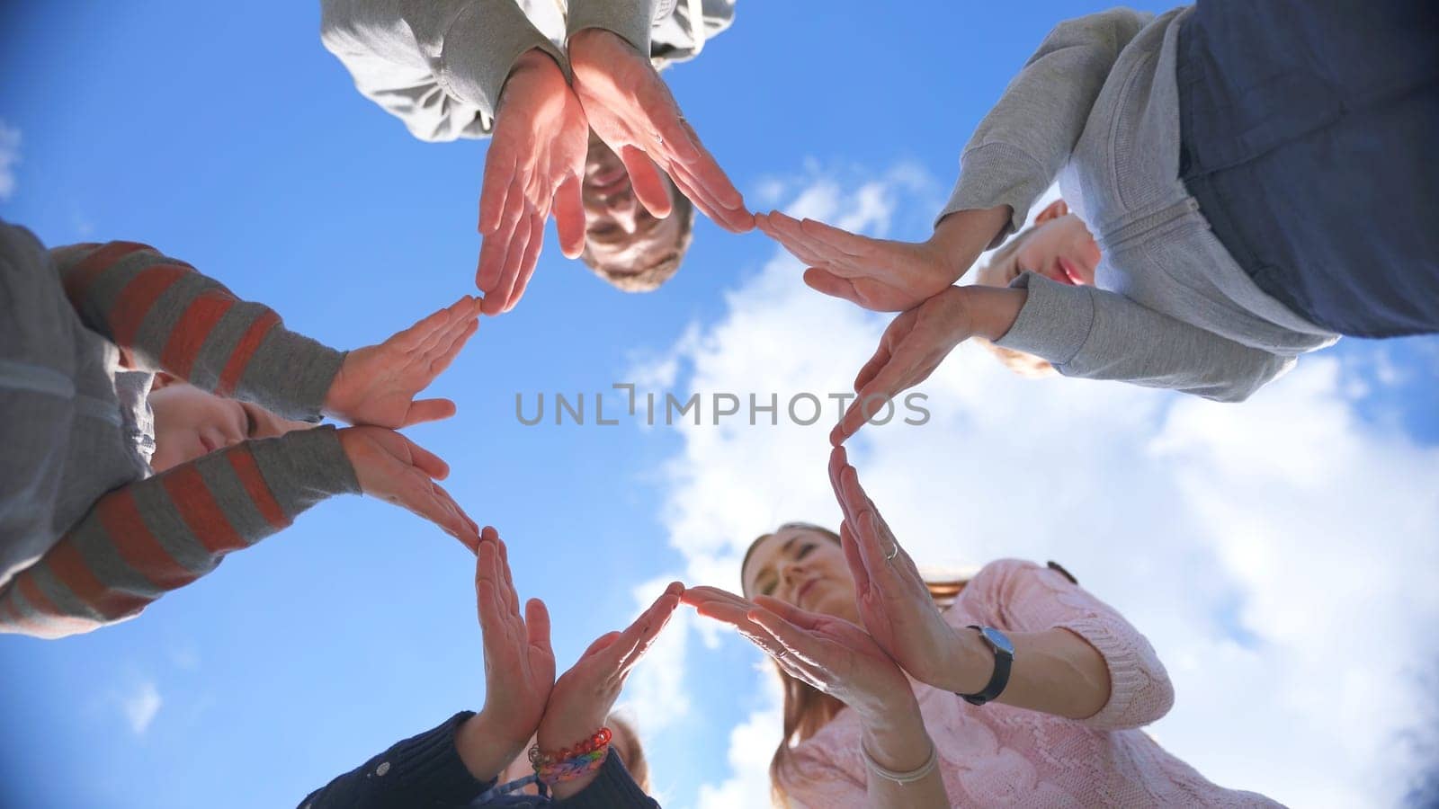 A friendly family makes a star shape out of their hands