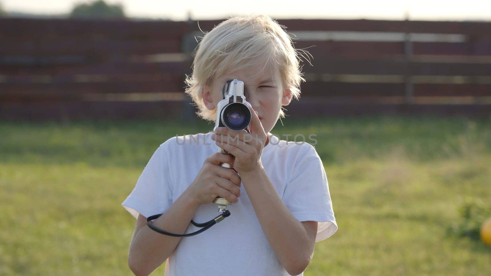 Little boy shoots a video of an old retro camera