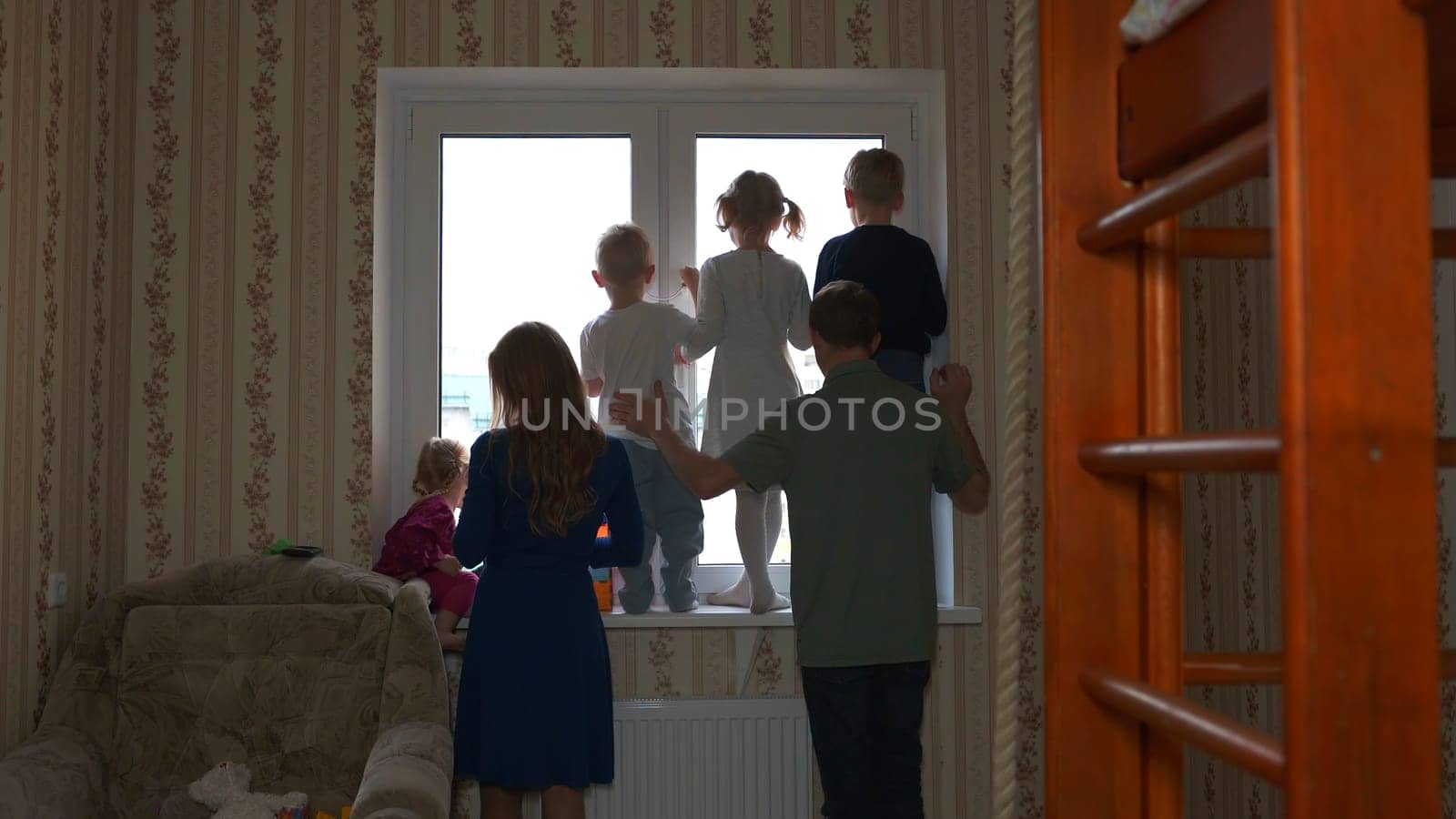 Silhouette of a large family on the background of a window in a new apartment. by DovidPro