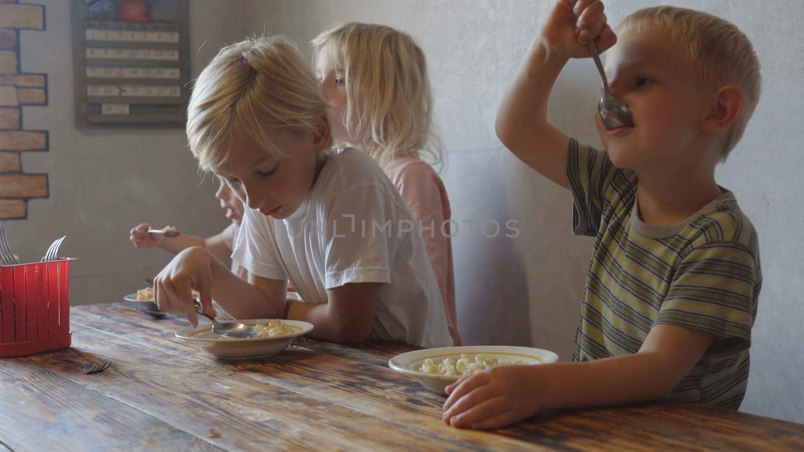 Funny beautiful childrens eat lunch at home. by DovidPro