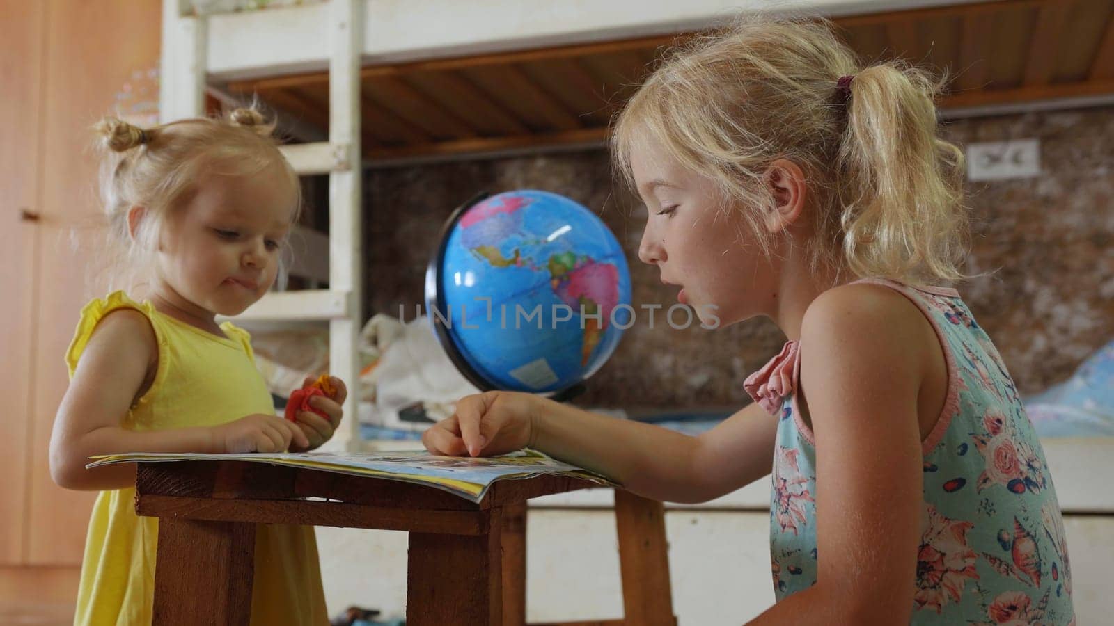 Two little girls are studying at home. by DovidPro