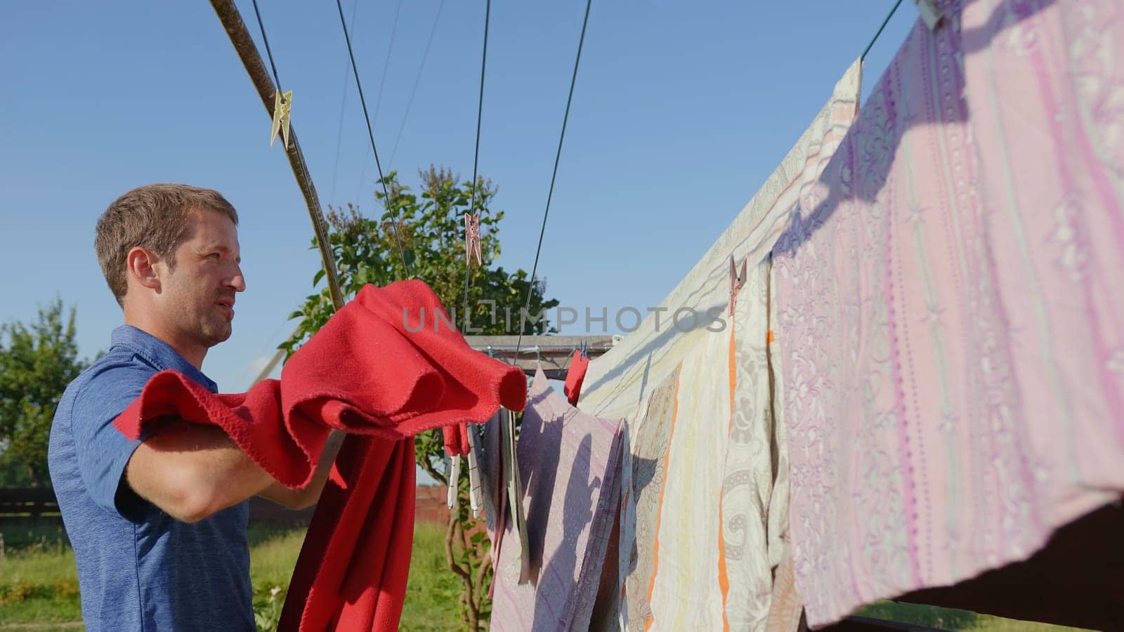 Caring husband hangs clothes on the street