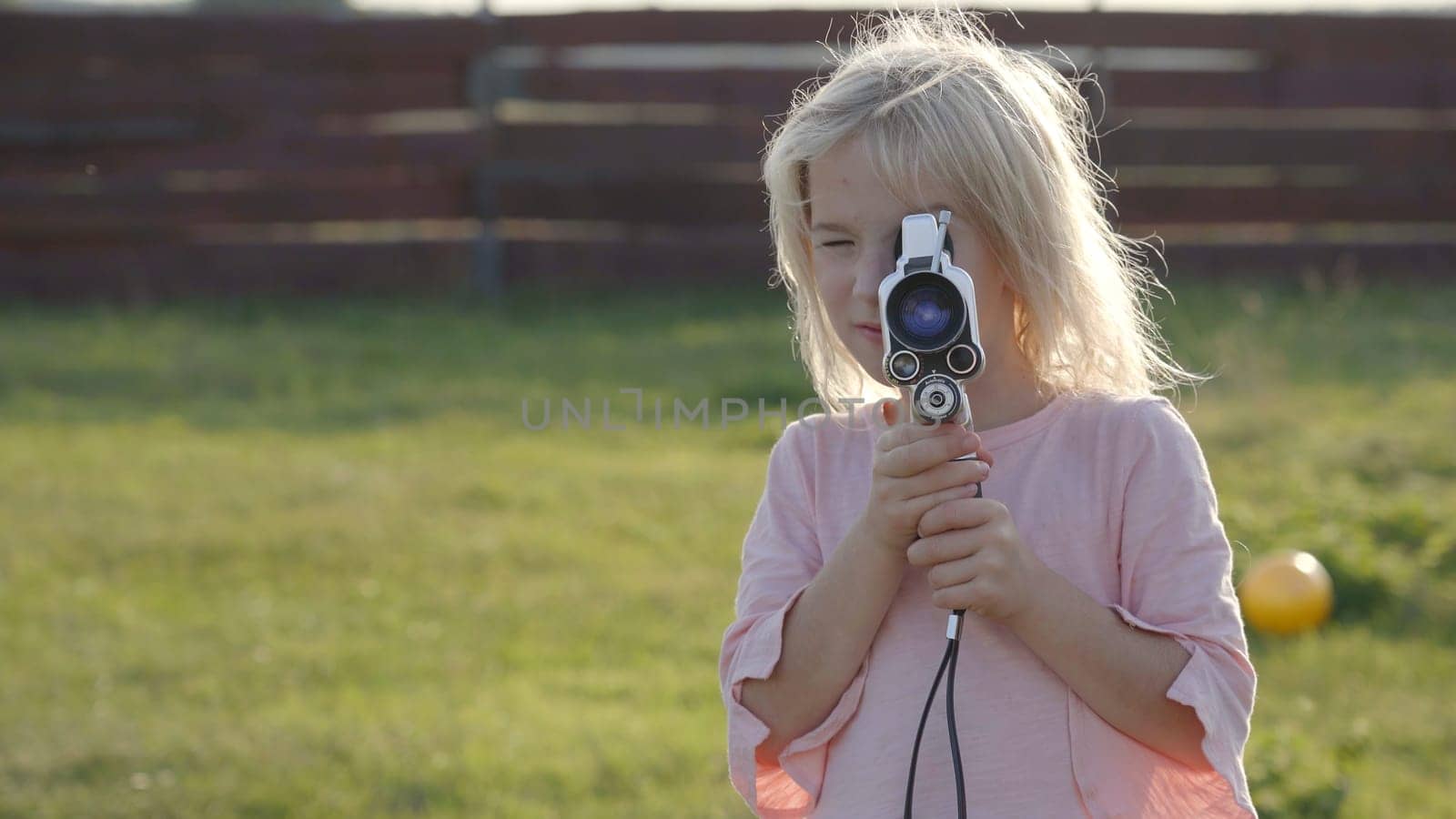 A little girl shoots a video of an old retro camera