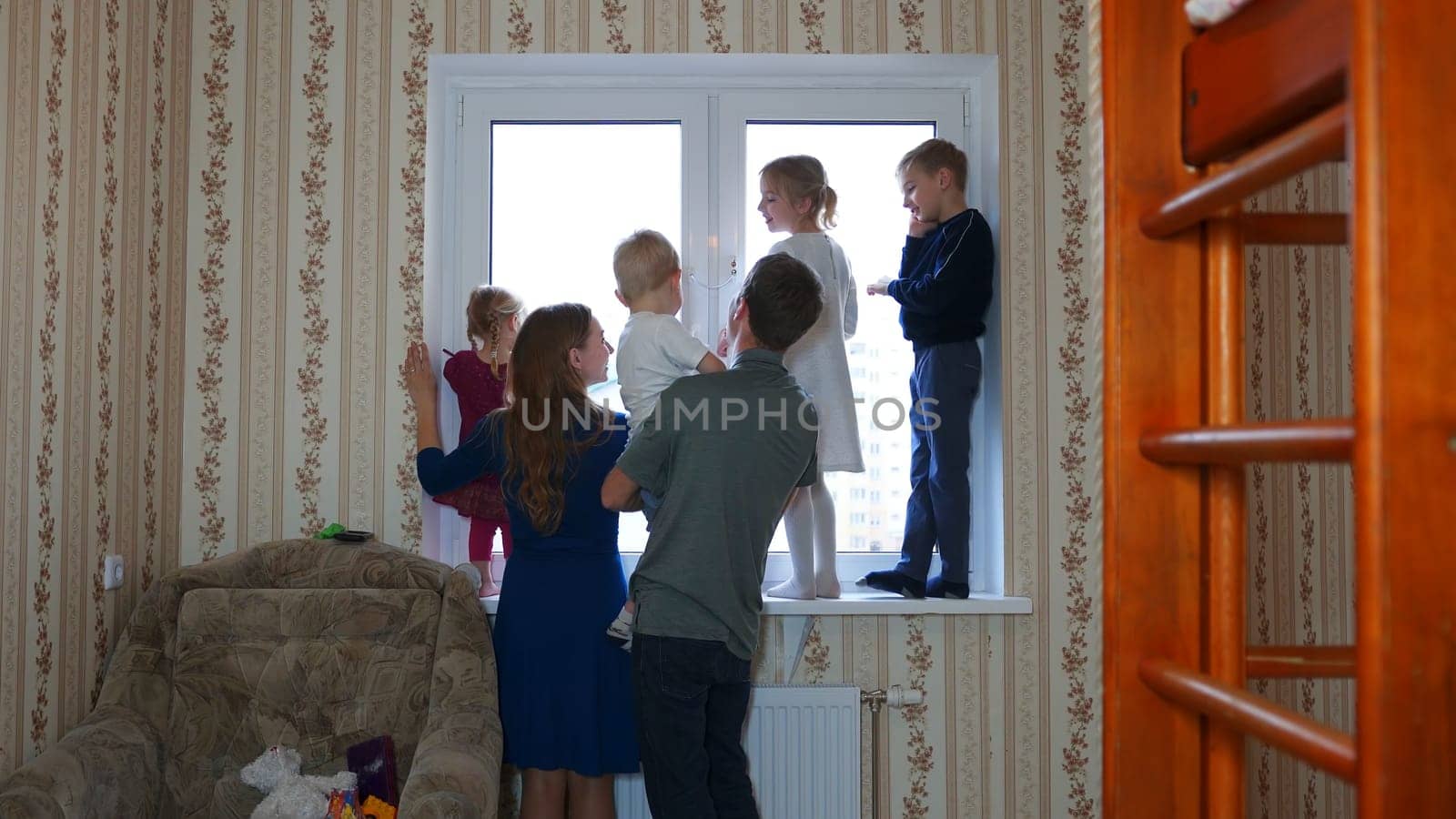 Large and friendly family at the window during quarantine