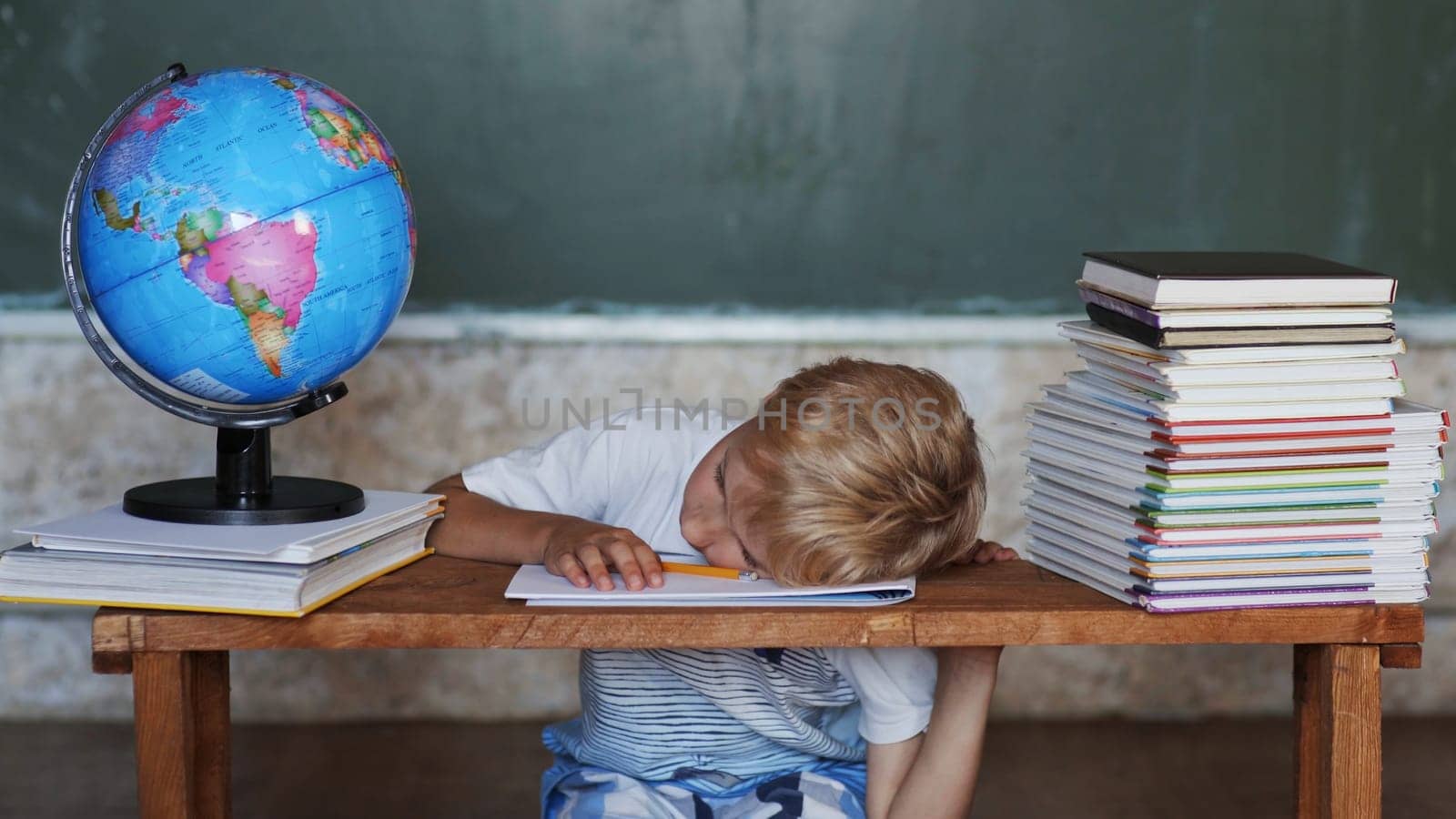 A boy of 8 years falls asleep from homework. Home school concept