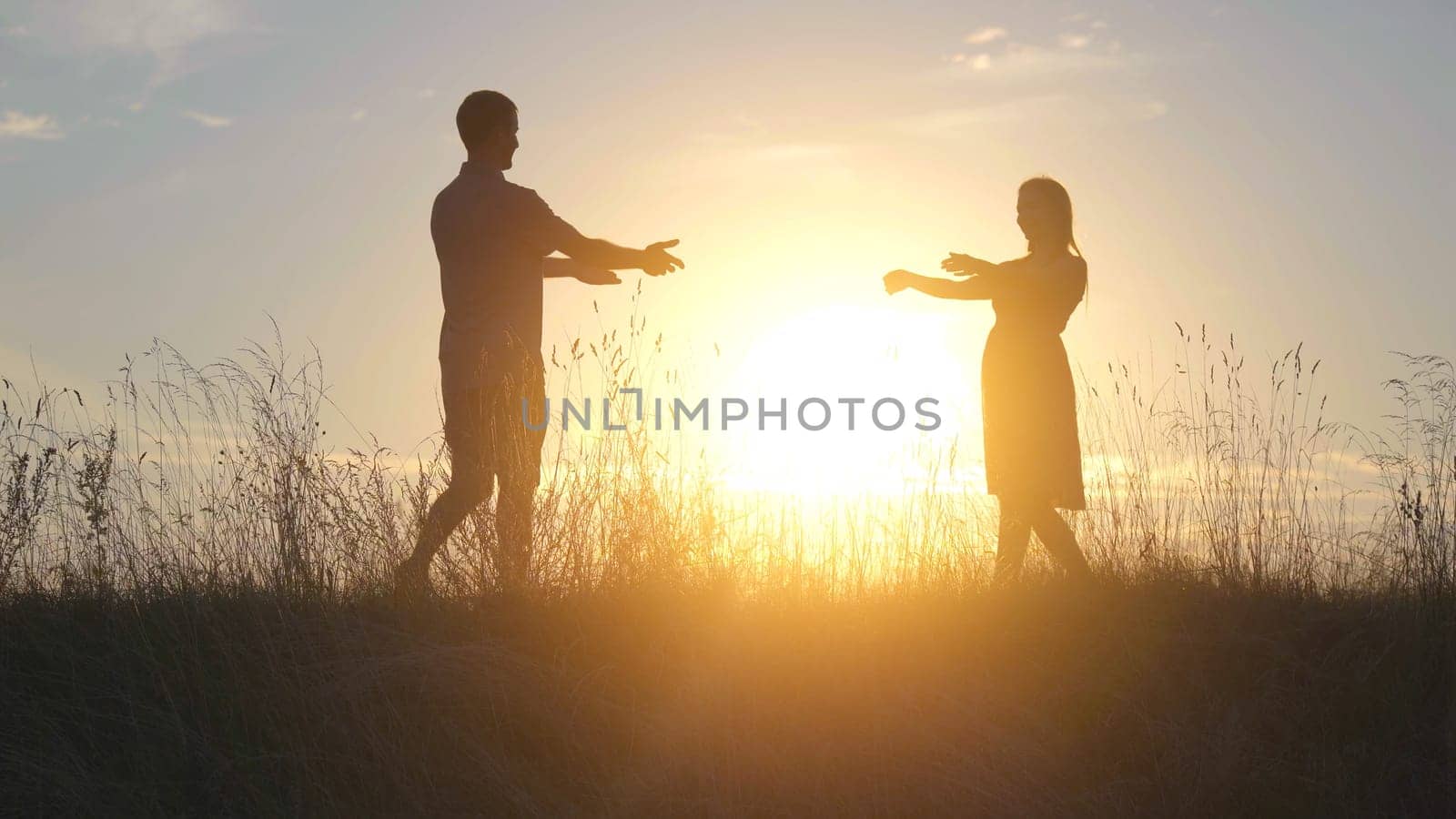 Silhouettes of a couple in love at sunset who meet and break up. by DovidPro