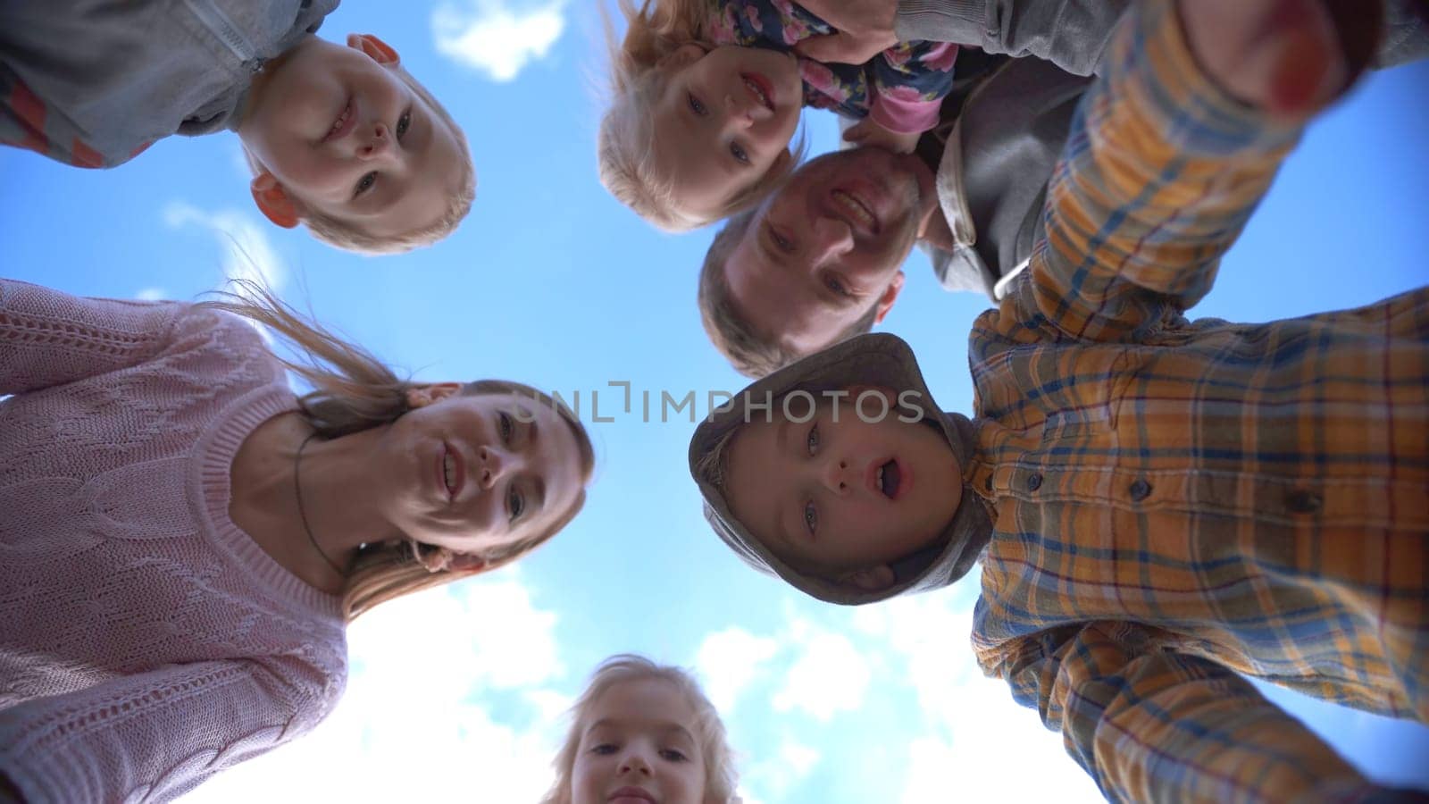 Happy young family with children opens the box and rejoices against the blue sky