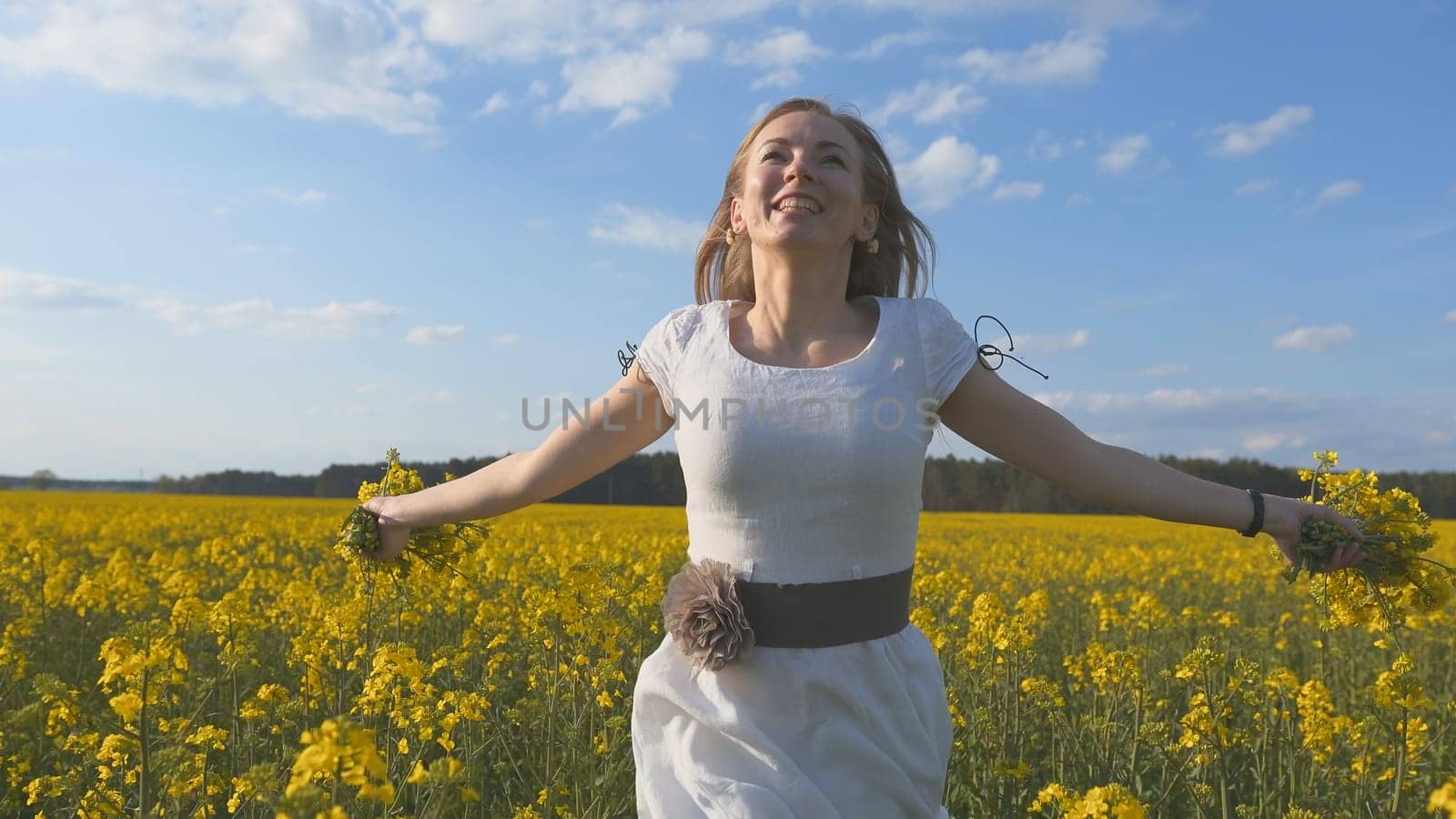 A girl in a white dress runs among a rapeseed field. by DovidPro