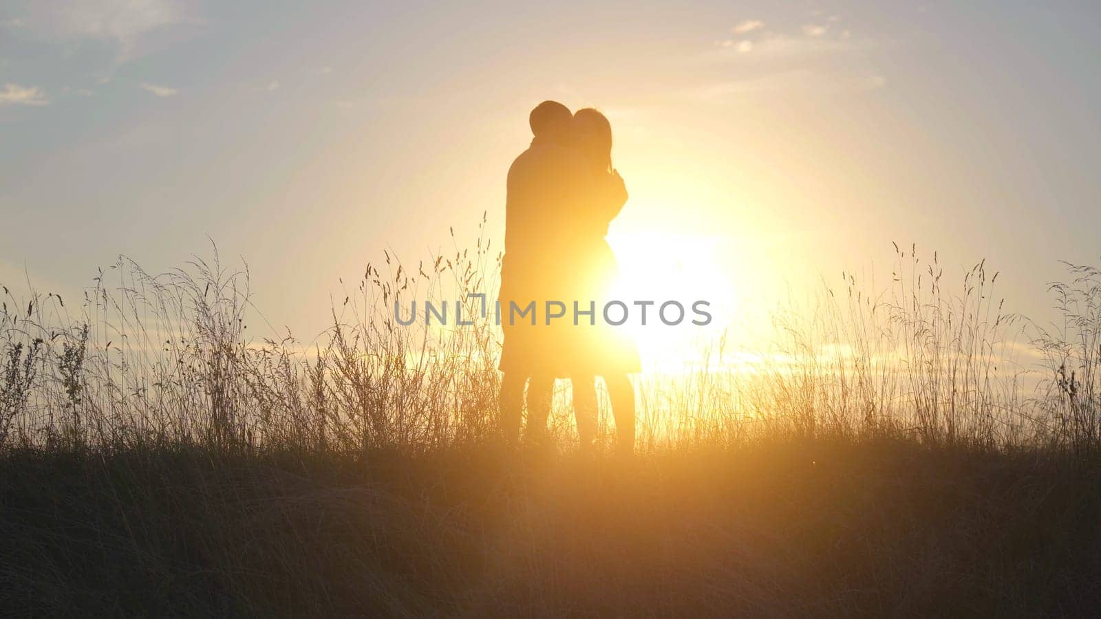 Beautiful young couple at sunset hugging tenderly. by DovidPro