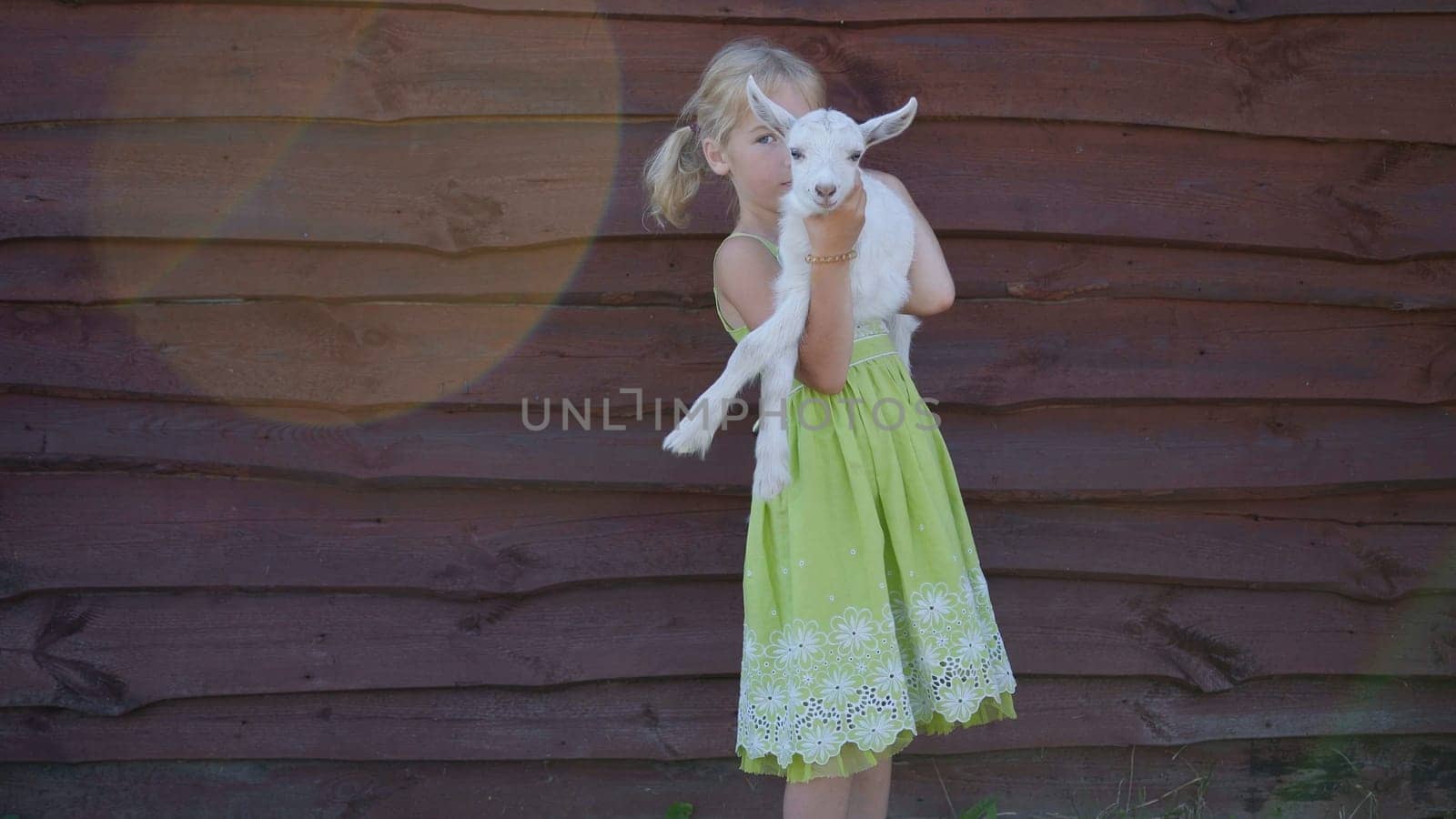 6 year old girl holding a small goat in her arms