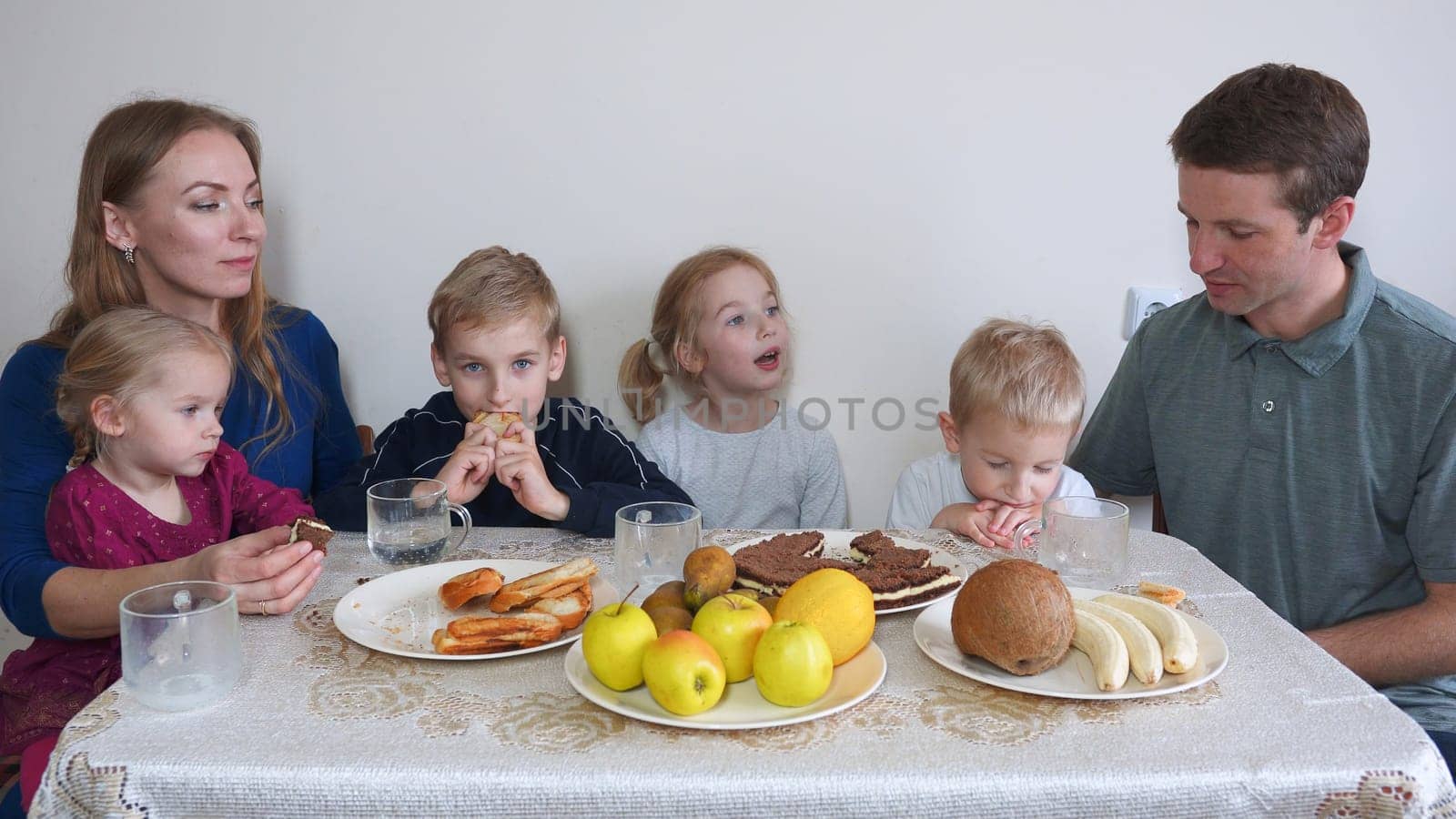 A large and friendly family has lunch at home. by DovidPro