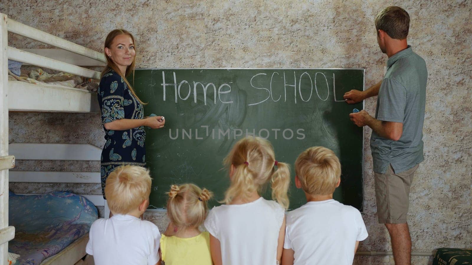 Home school concept. Parents write Home School on the blackboard