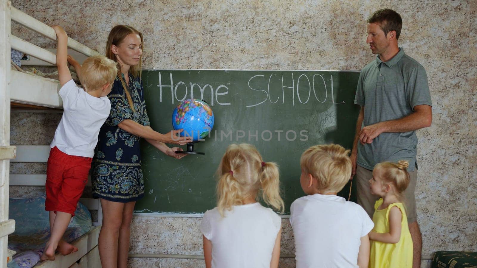 Home school concept. Parents teach their children with a globe in their hands. by DovidPro
