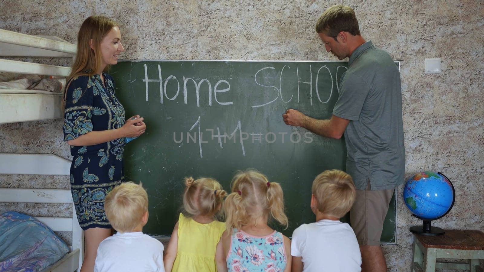 Home school concept. Parents give children a math lesson at the blackboard