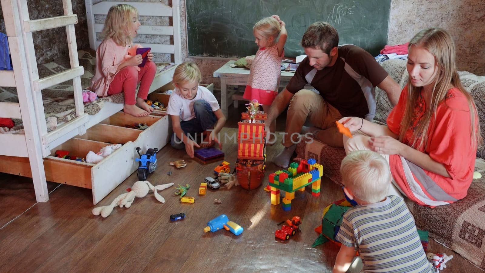 A friendly family with children playing toys at home