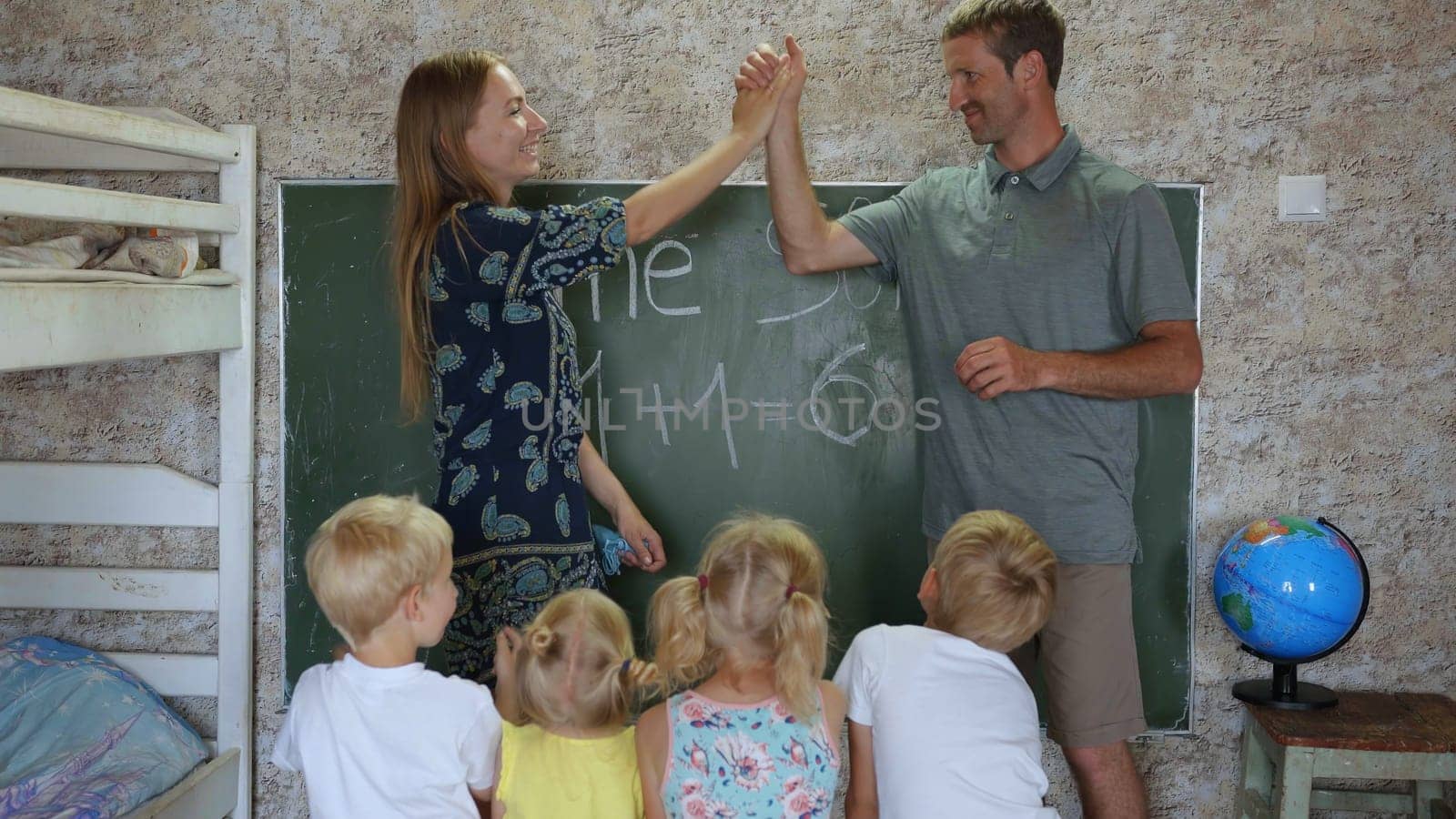 Home school concept. Parents give children a math lesson at the blackboard