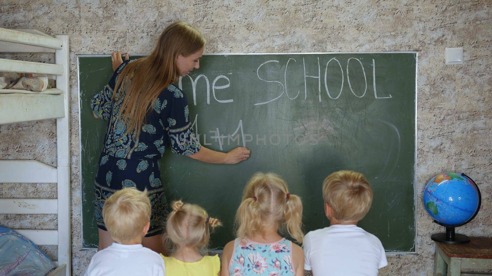 Home school concept. Mother give children a math lesson at the blackboard. by DovidPro