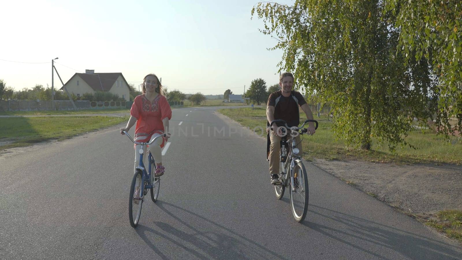 A loving couple on bicycles in the evening. by DovidPro