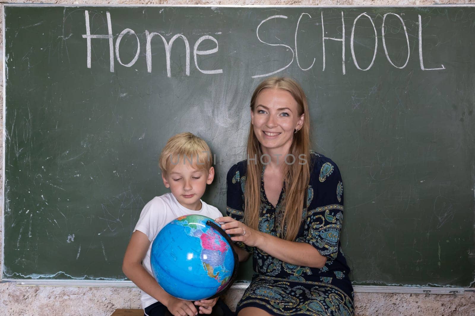 Mother is studying a world map on a globe with her son