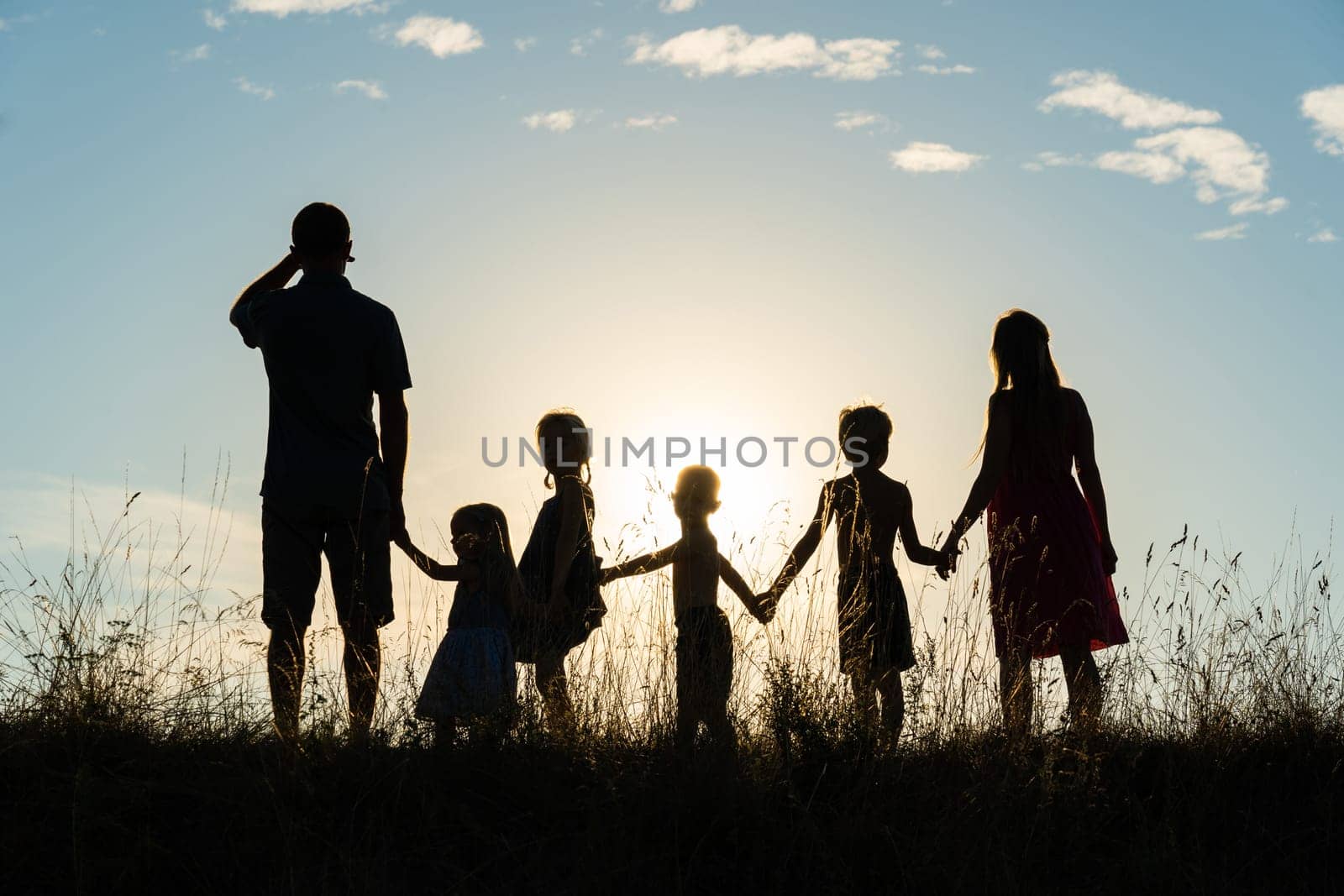 Silhouette of a happy large family at sunset