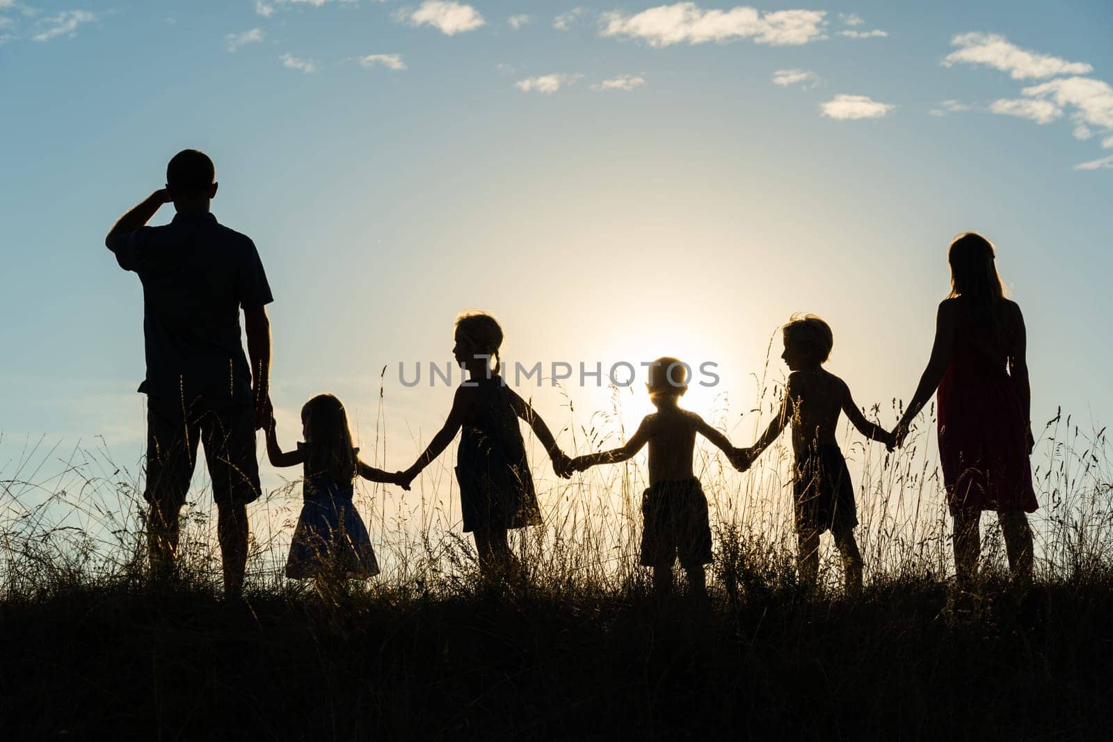 Silhouette of a happy large family at sunset