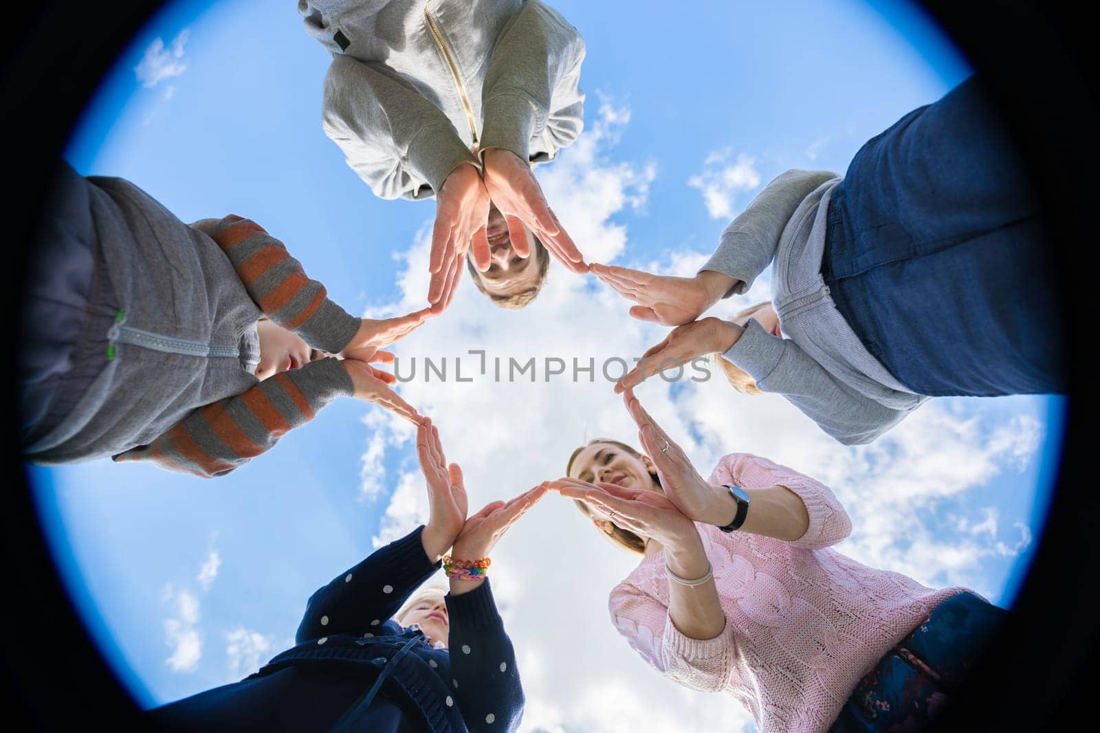 A friendly family makes a star shape out of their hands. by DovidPro