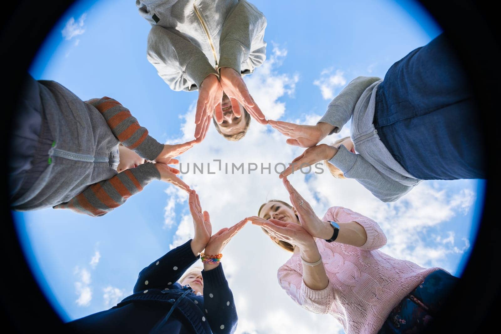 A friendly family makes a star shape out of their hands