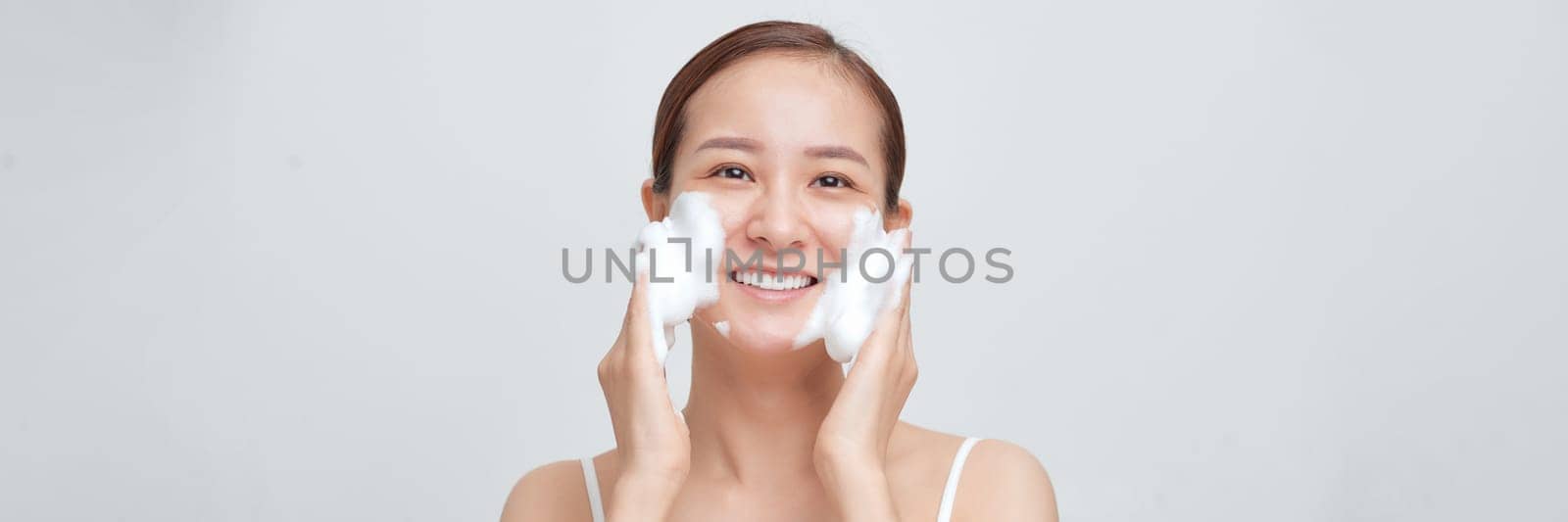 happy woman with foaming facial cleanser washing face isolated on white banner background.