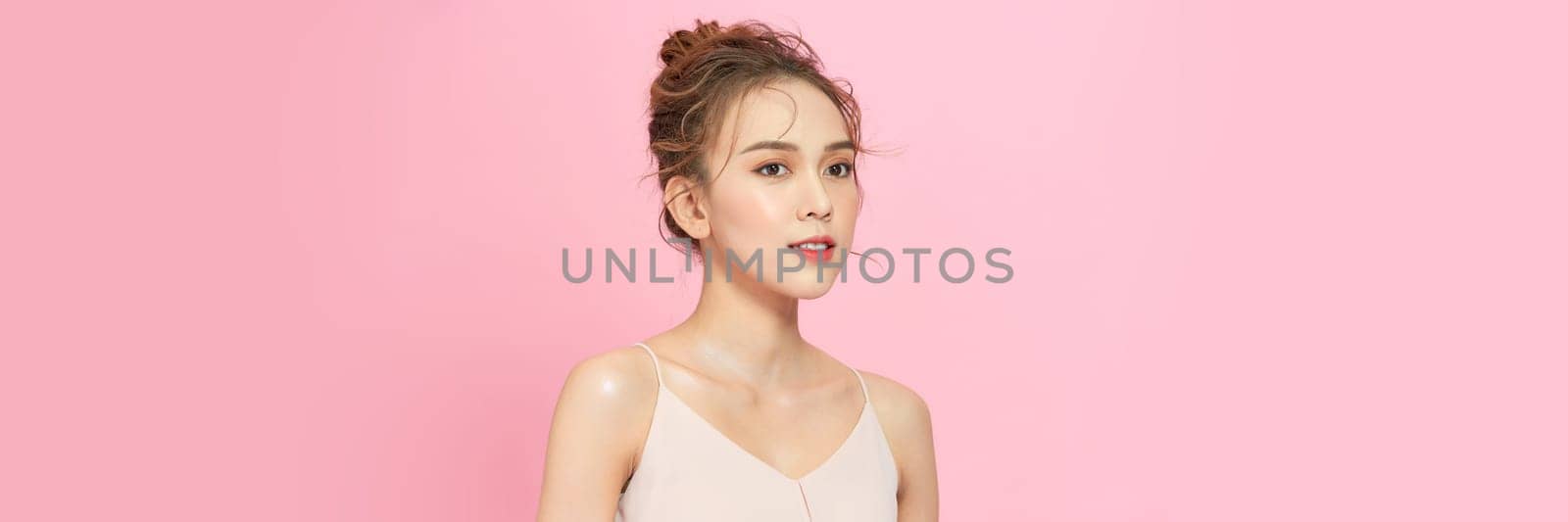 Young woman posing alone, portrait isolated on pink studio background by makidotvn