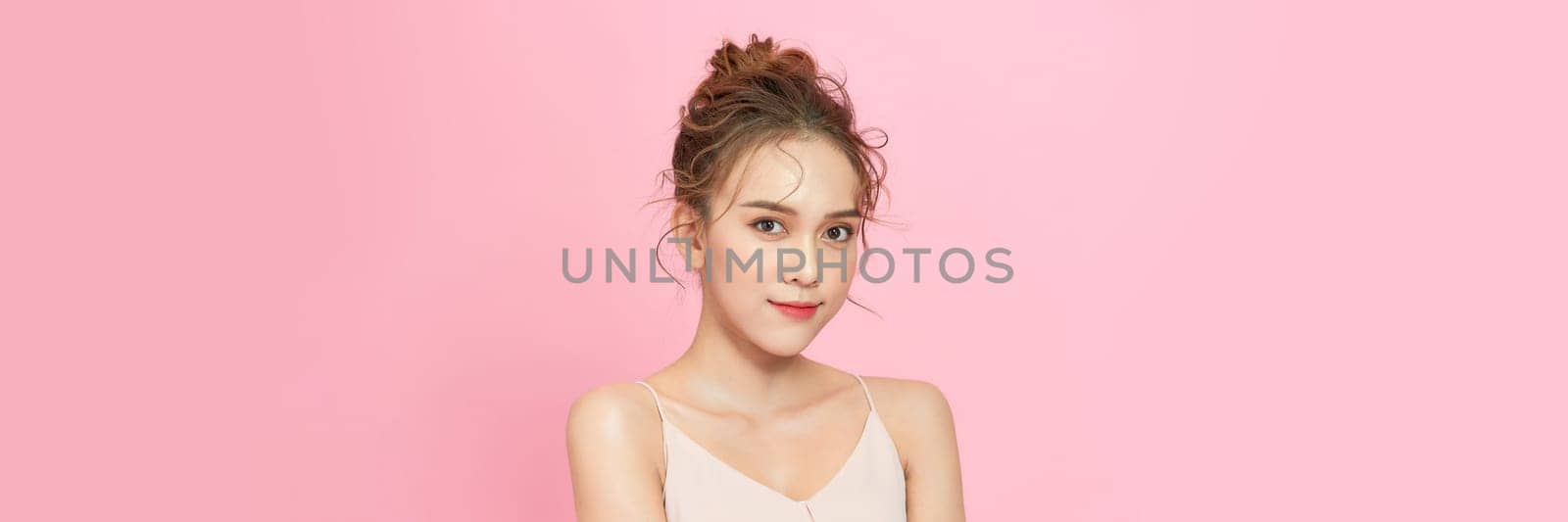 Young woman posing alone, portrait isolated on pink studio background