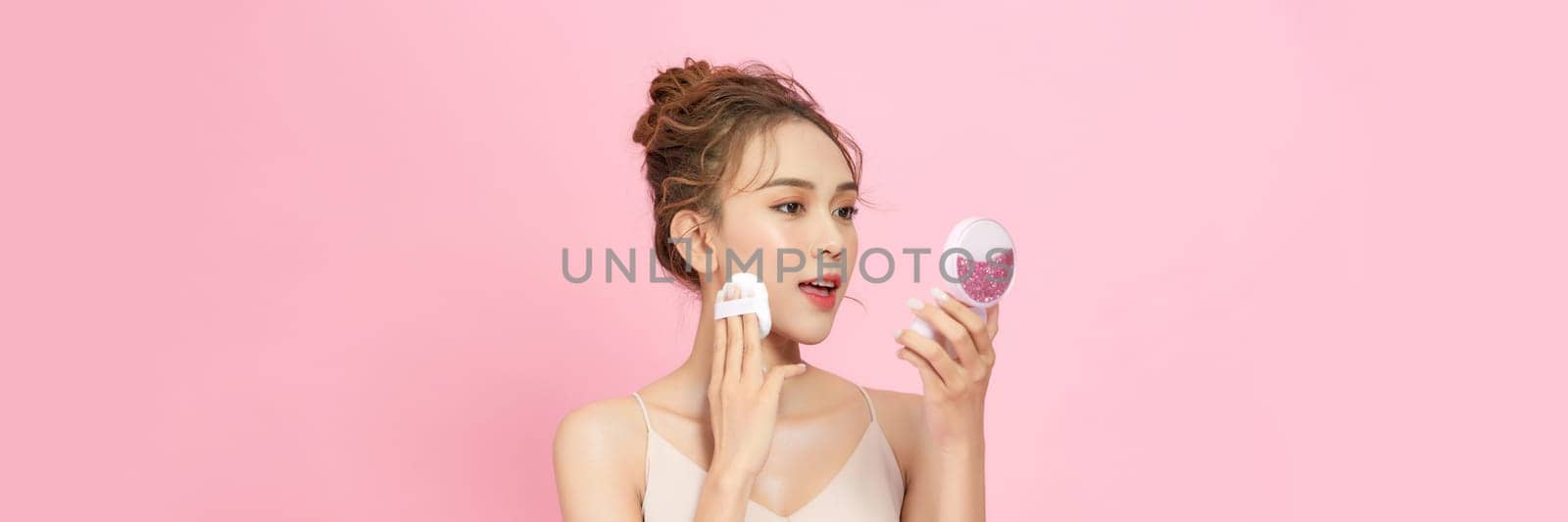 Portrait of beautiful asian woman applying powder puff at cheek makeup of cosmetic,  by makidotvn