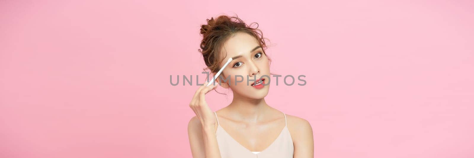 Young beautiful model with beauty face applying makeup.  by makidotvn