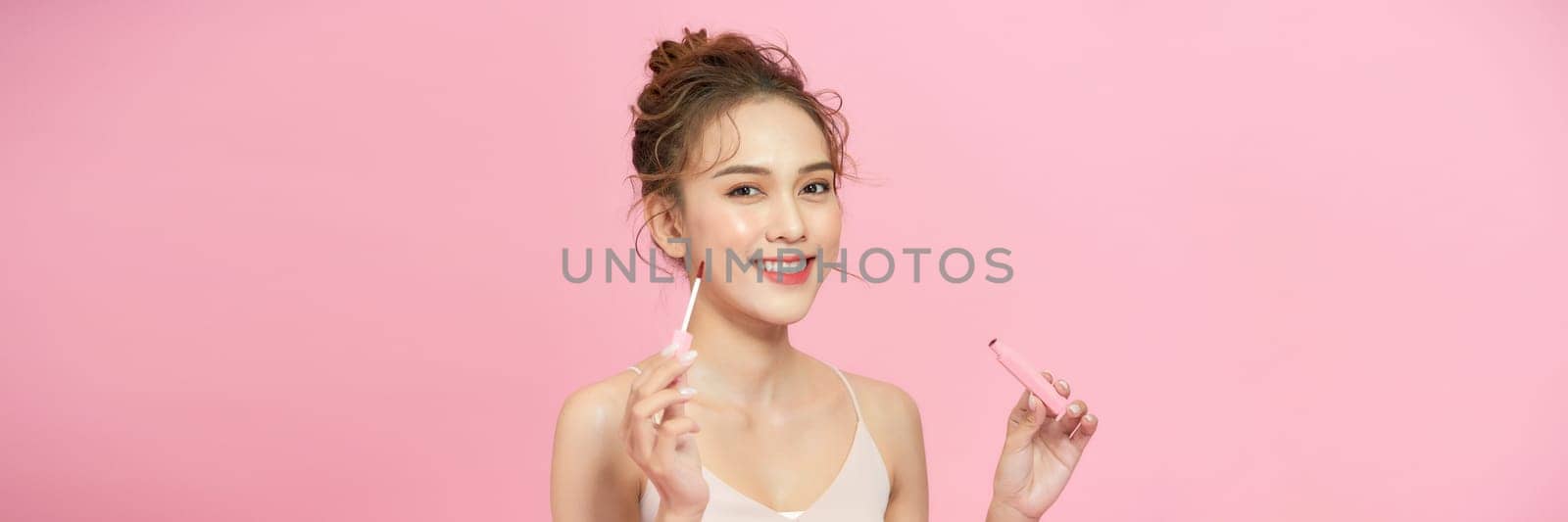 Attractive and beautiful Asian girl paint lips a pink lipstick by makidotvn