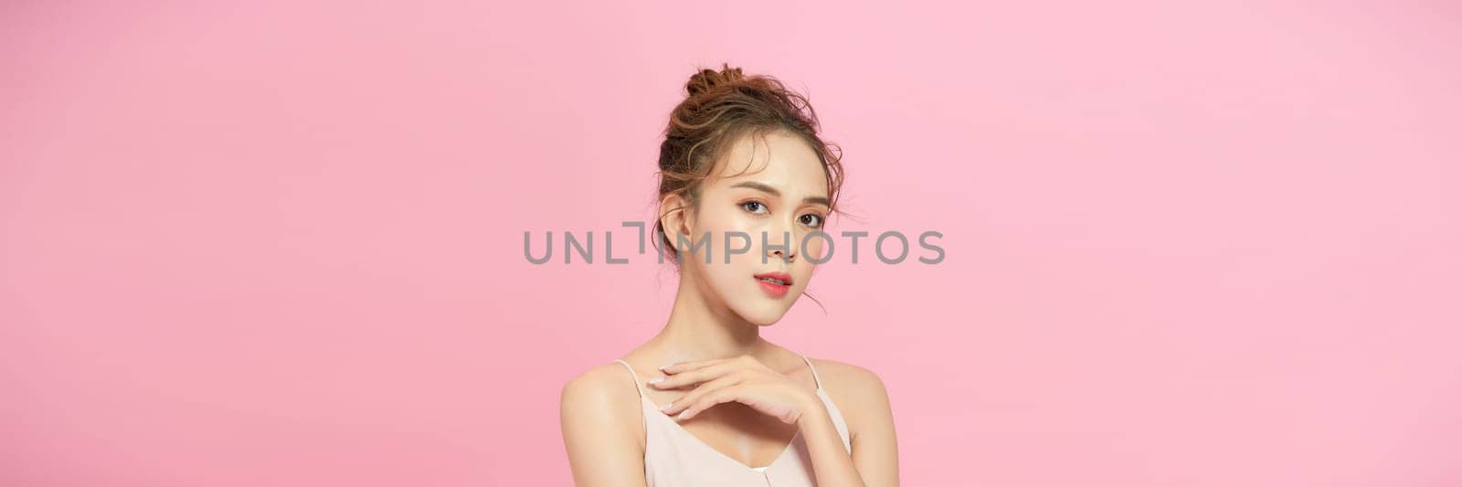 Beautiful young asian woman with clean fresh skin on pink background,  by makidotvn