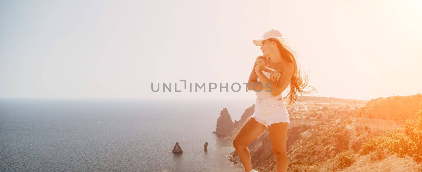 Woman summer travel sea. Happy tourist enjoy taking picture outdoors for memories. Woman traveler posing over sea bay surrounded by volcanic mountains, sharing travel adventure journey by panophotograph