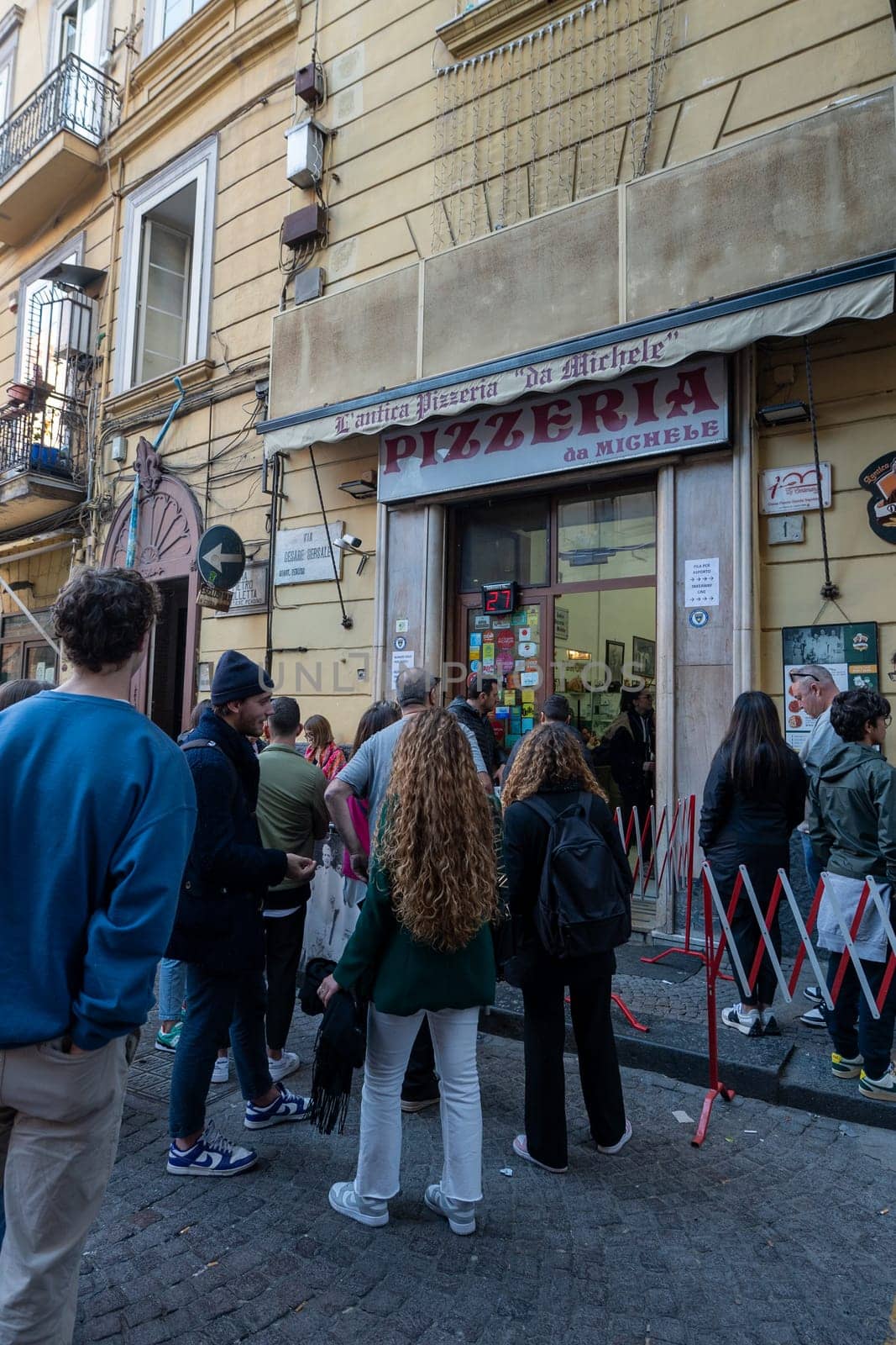 Napoli, Italy: 2023 November 18: People waiting on the street at La Antica Pizzeria Da Michele from 1870 where the authentic Margherita pizza is made in November 2023.