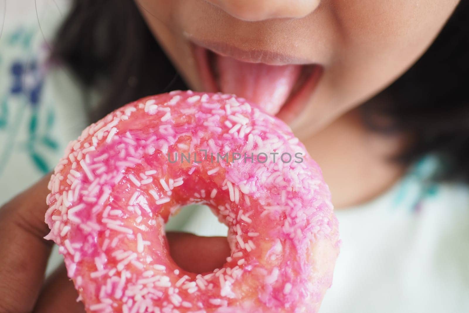 child mouth eating chocolate donuts .
