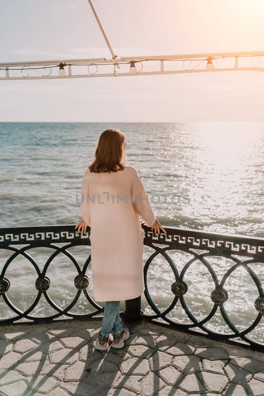 Woman summer travel sea. Happy tourist enjoy taking picture outdoors for memories. Carefree woman traveler posing on beach at sea on sunset, sharing travel adventure journey. Holiday vacation concept. by panophotograph